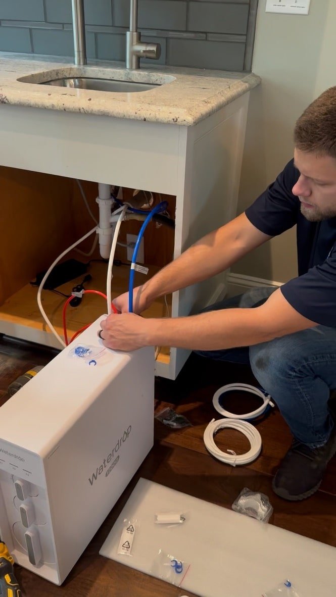 man installing the water filtration system cords