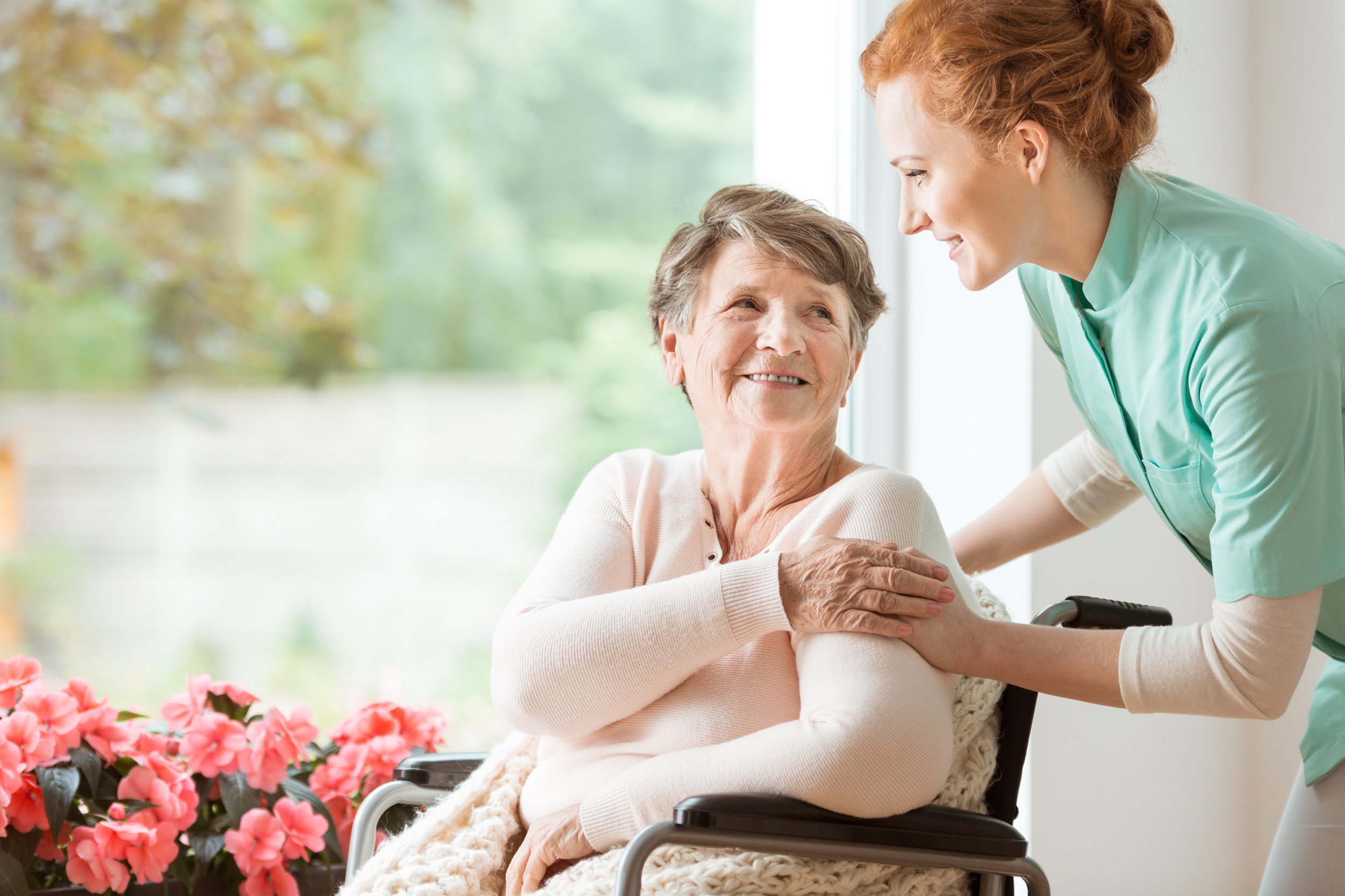 A caregiver attending to an elderly woman