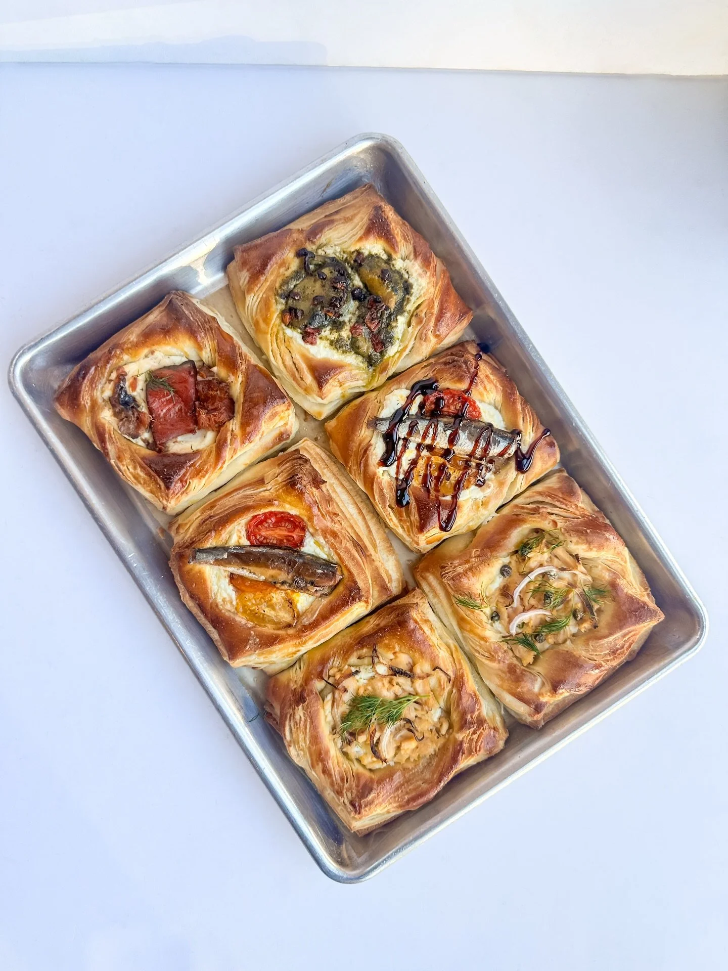 Combining my two favorite things: Scandi pastry + tinned fish! 

Coming next week is our tinned fish Danish 🐟🥐

Currently experimenting with:
- ricotta, lemon zest, roasted tomatoes, balsamic glaze w/ @patagoniaprovisions white anchovies &amp; garl