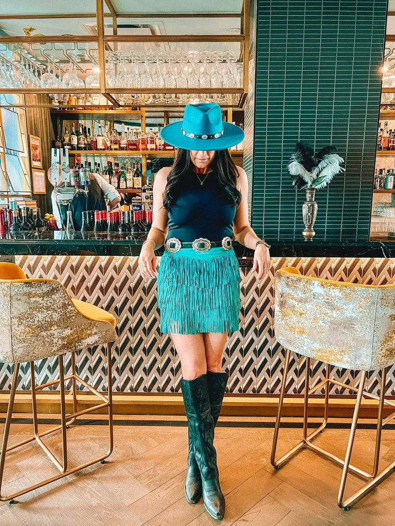cowgirl leaning against bar