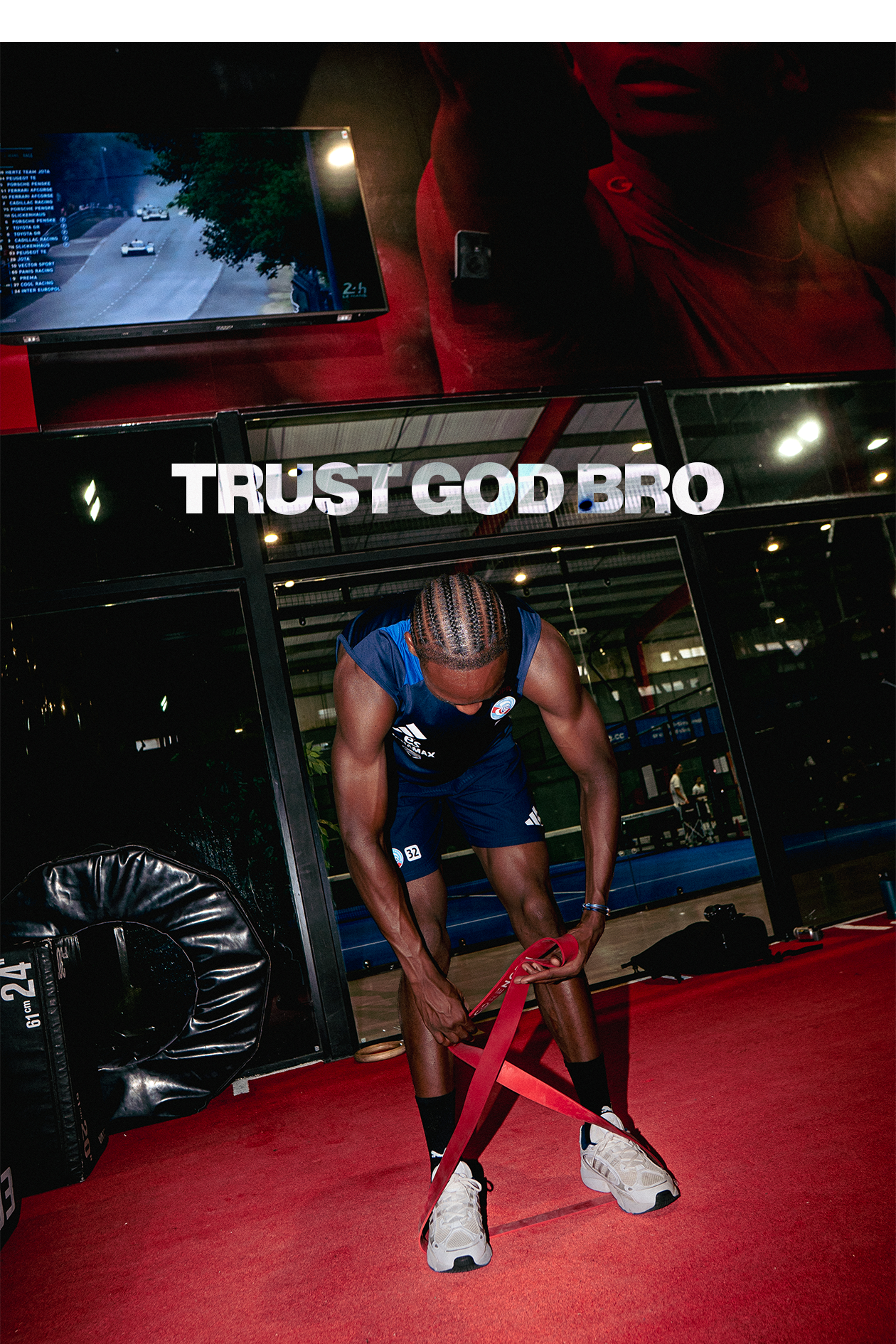 Un homme musclé, en tenue de sport, en train de faire des exercices avec une bande de résistance dans une salle de sport. Le texte 'TRUST GOD BRO' est écrit en gros caractères blancs au-dessus de lui.