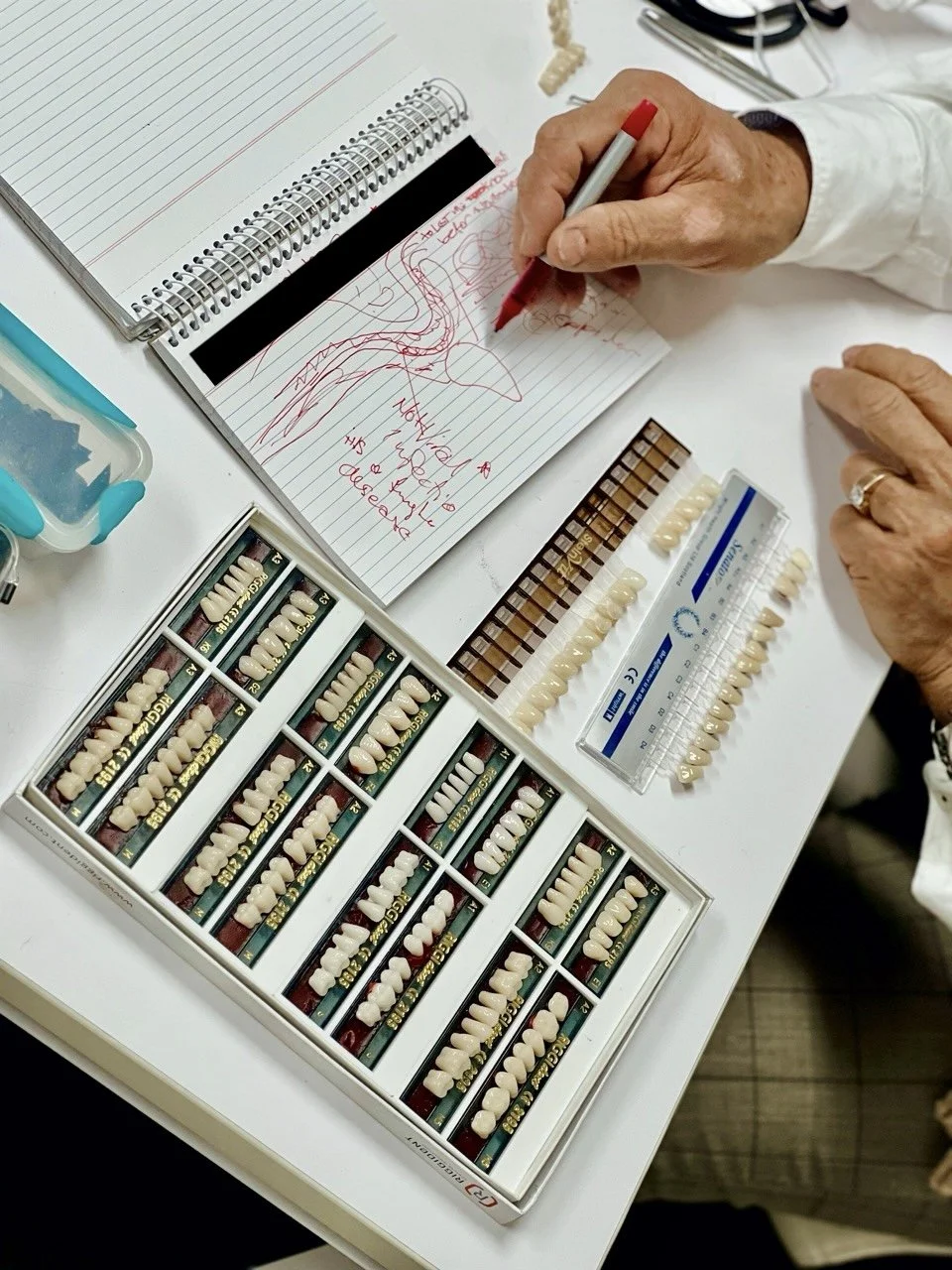 A professional selection of premium QiQdent teeth alongside hand-drawn clinical notes for a custom denture build by Dr Sebastian Riggio.