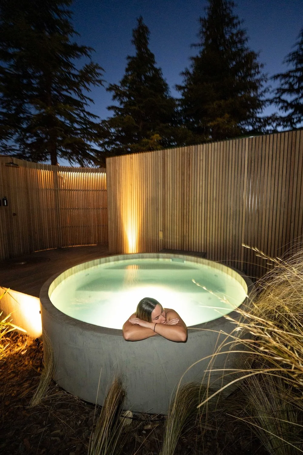 A Bather relaxing in a hot tub at night at Bathe Queenstown.