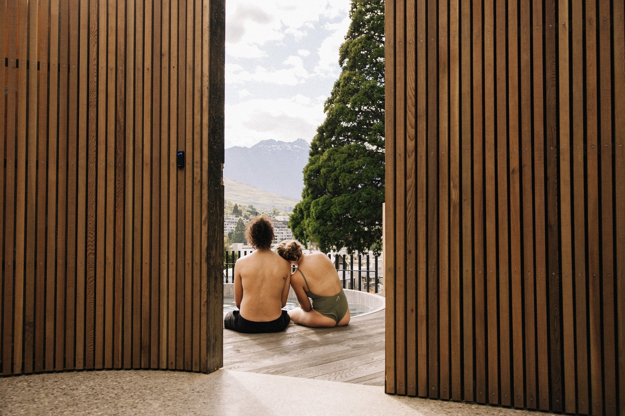 A perfect date activity, a couple sitting poolside at Bathe Hot Pools Queenstown.