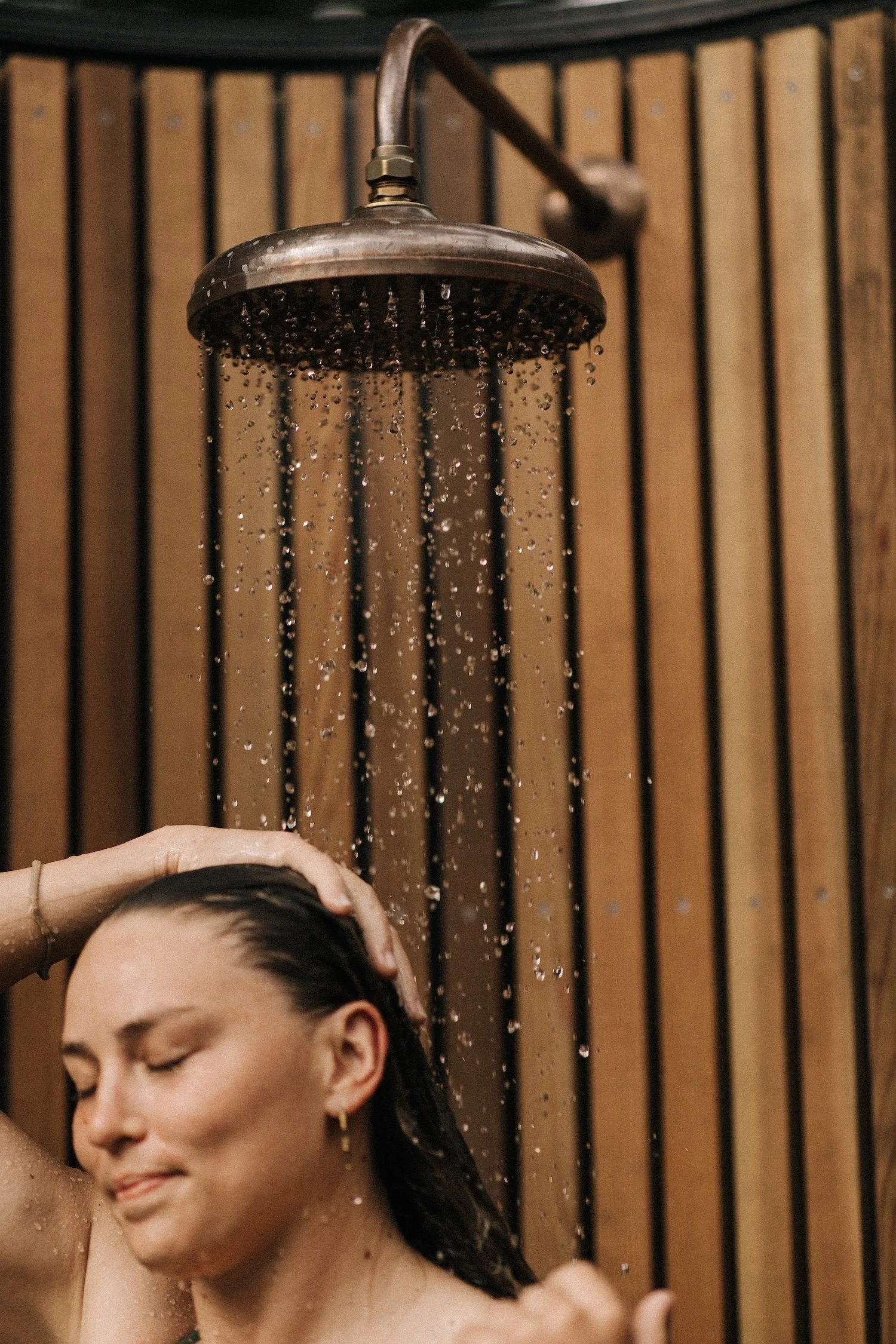 A Bather showering in the poolside showers at Bathe Queenstown.