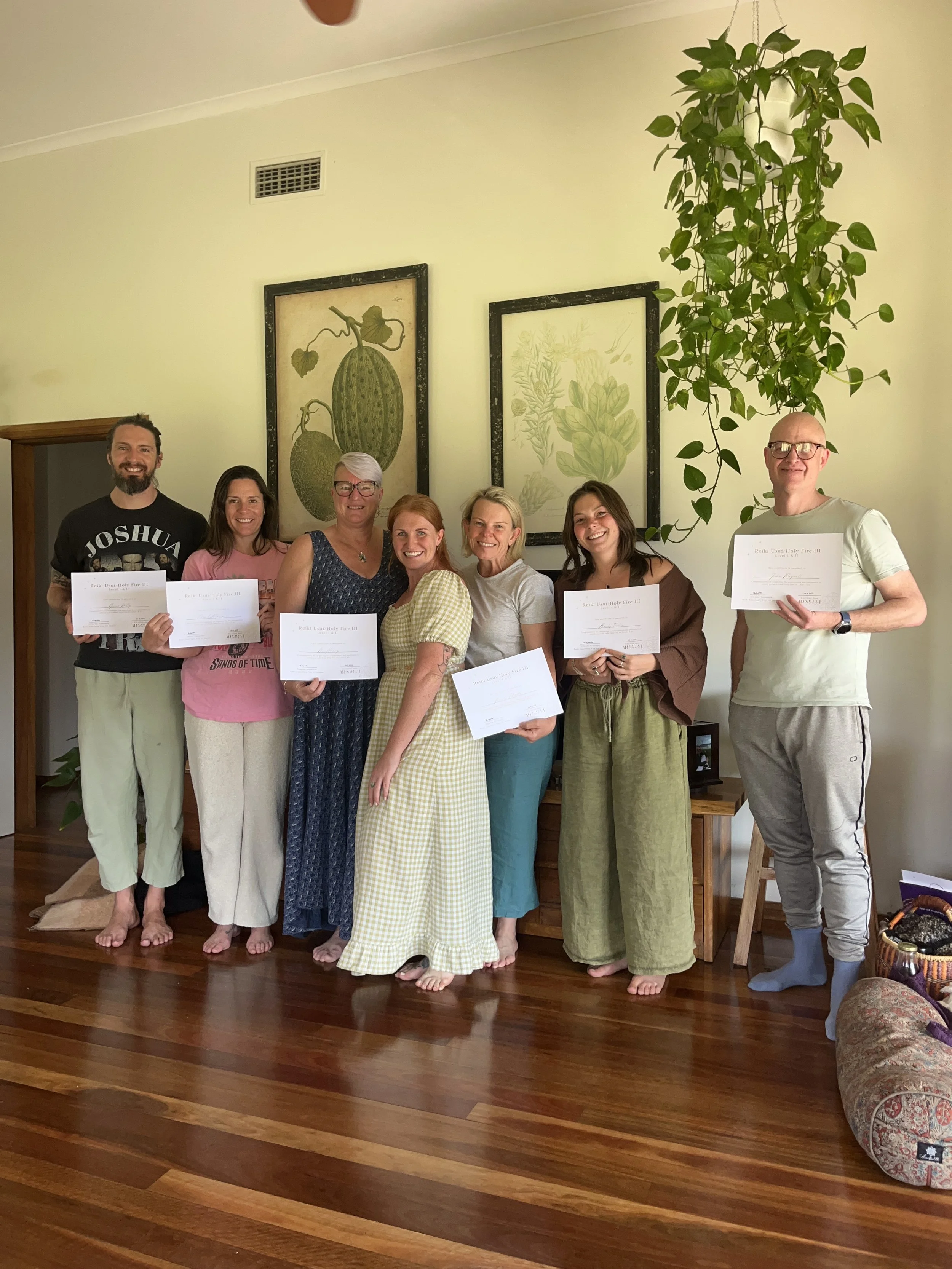 Group of smiling people showing their Reiki Certificate