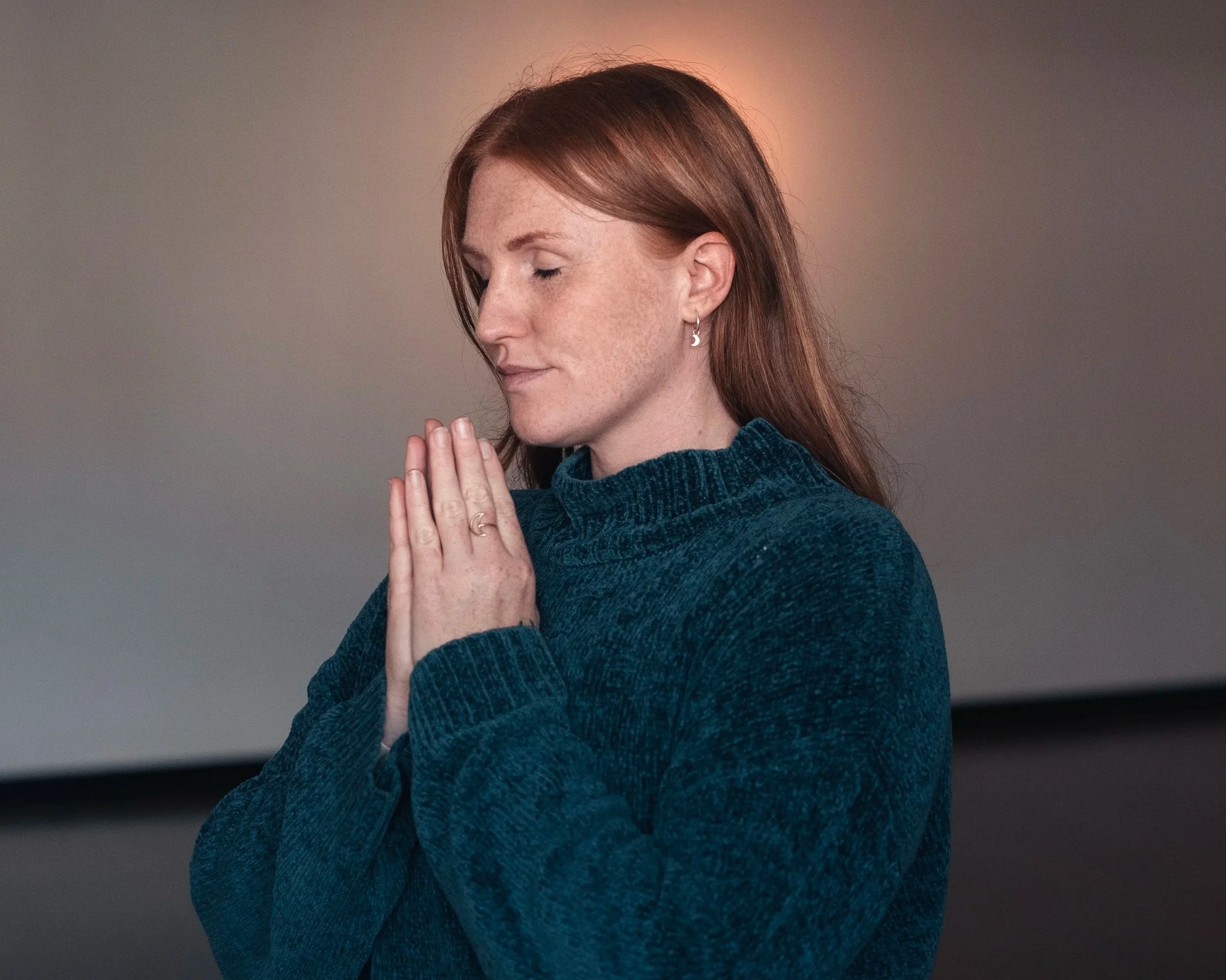 Woman in gassho meditation preparing to channel Reiki Holy Fire