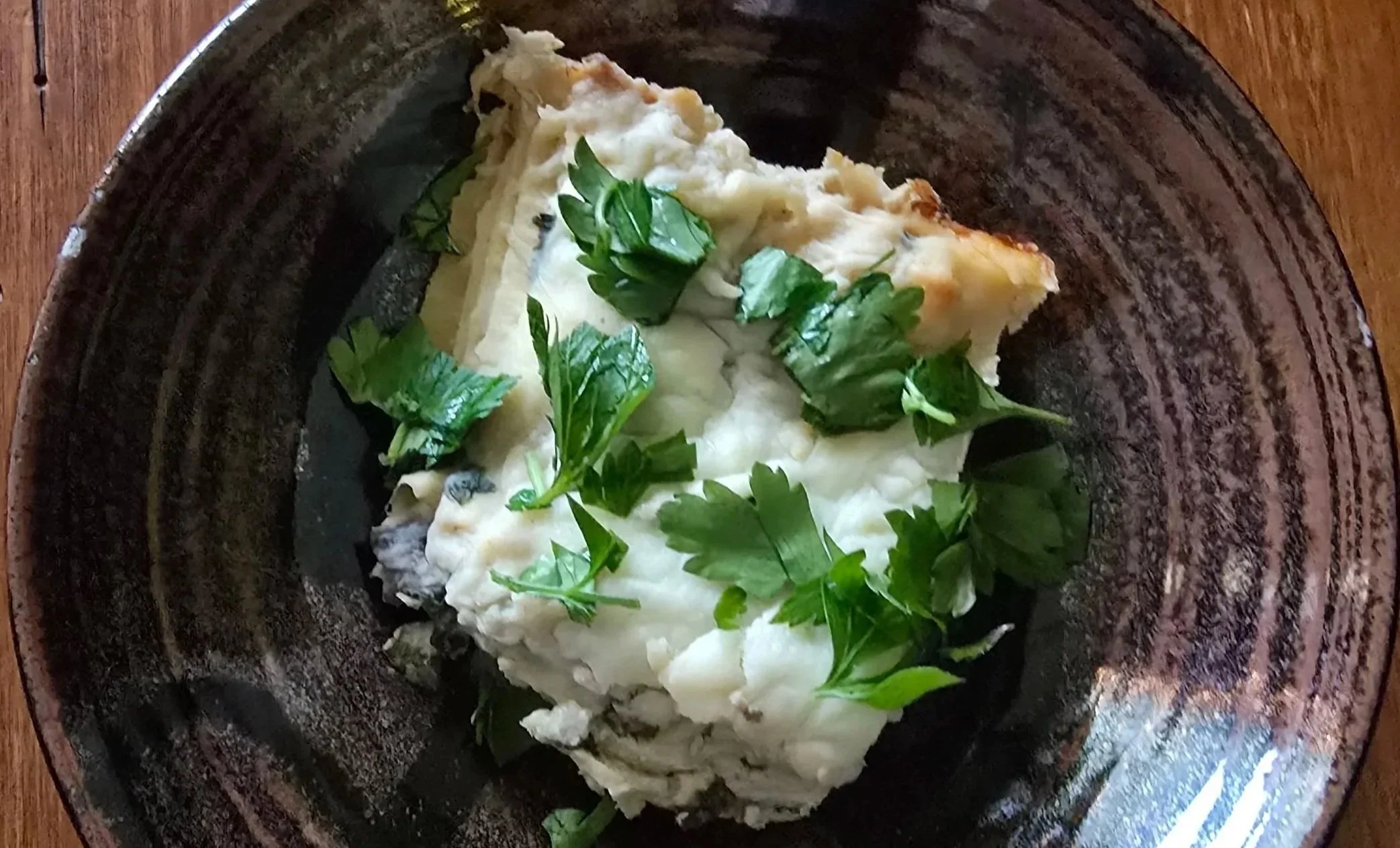 Creamy mushroom, zucchini, and spinach white lasagna baked until golden and garnished with fresh parsley