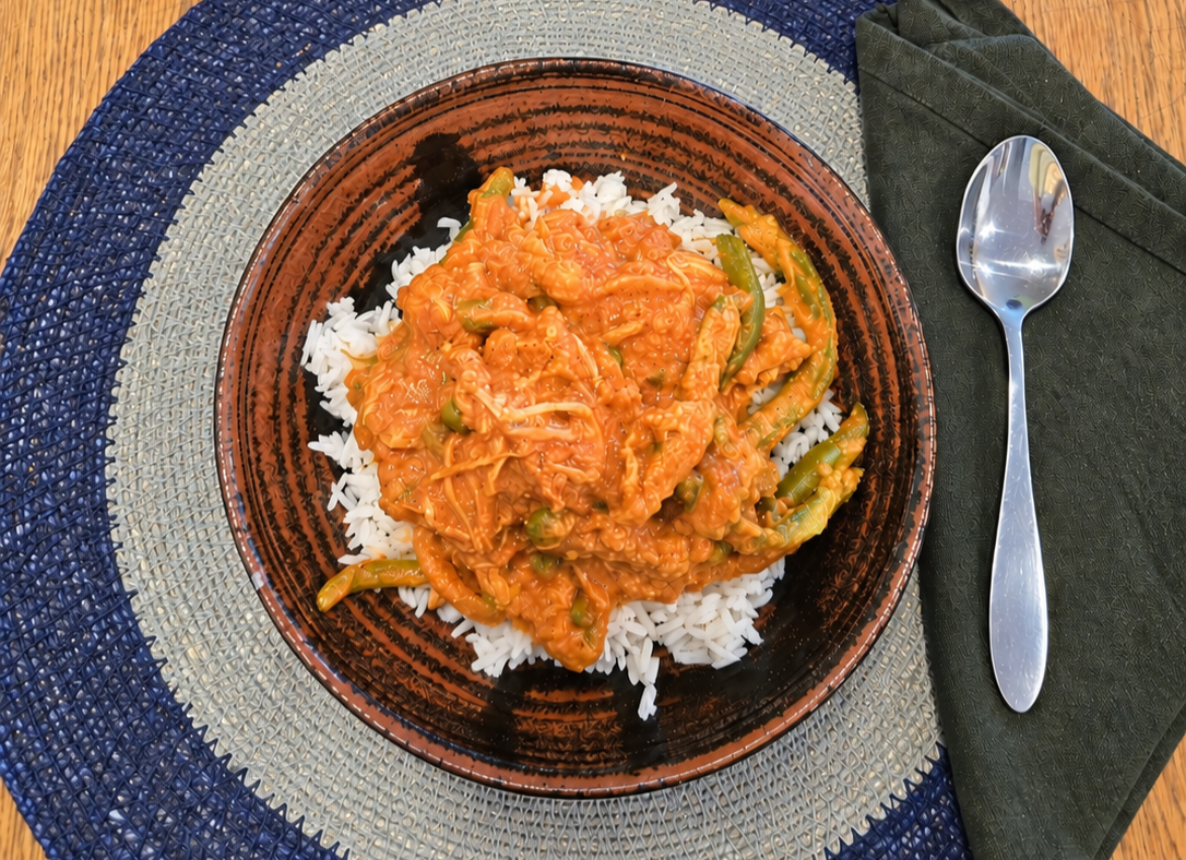 Creamy Slow Cooker Chicken Tikka Masala with tender chicken, green beans, and peas served over rice and topped with fresh cilantro.