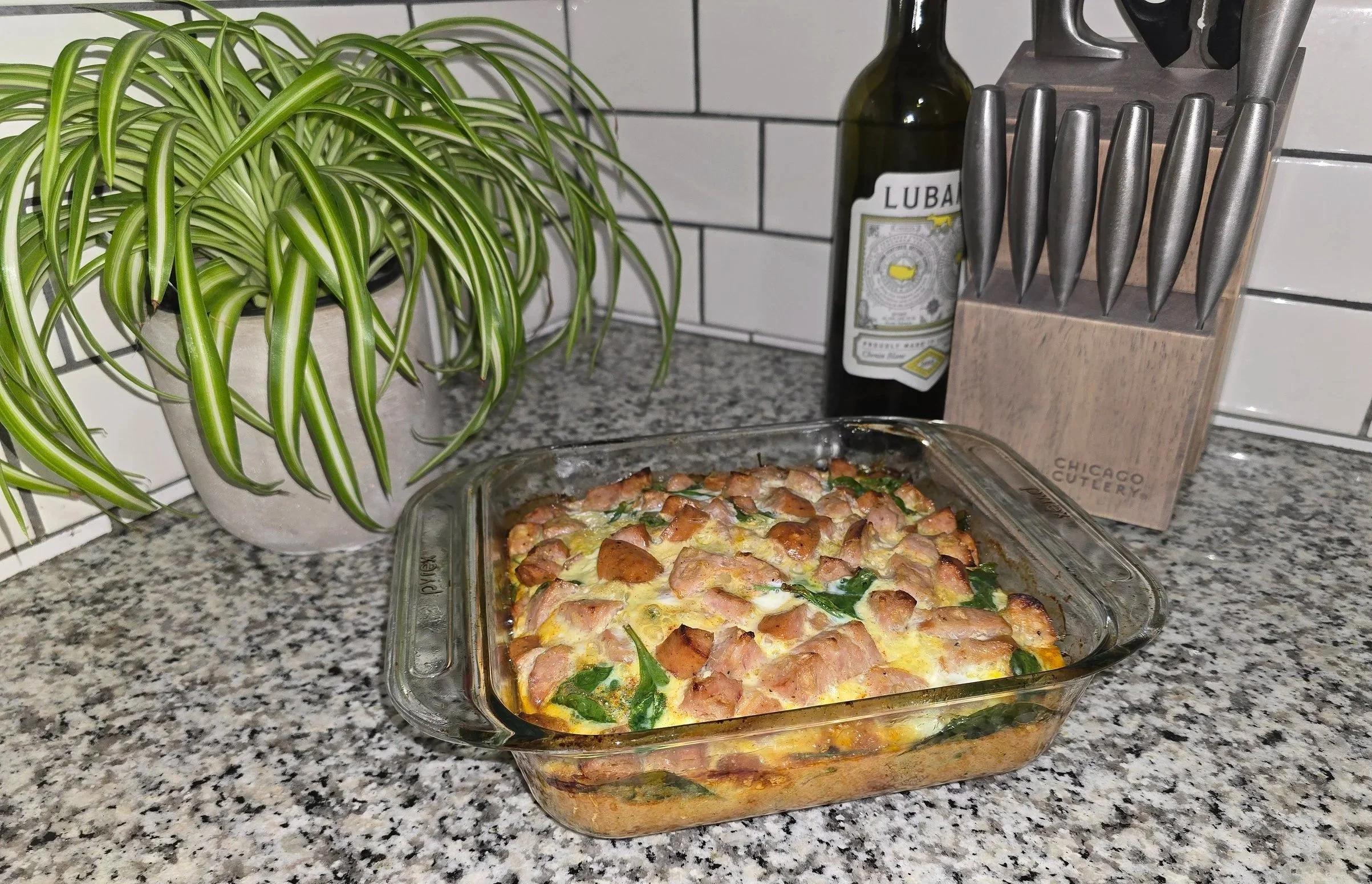 Sweet potato, spinach, and sausage breakfast bake sliced in a glass baking dish