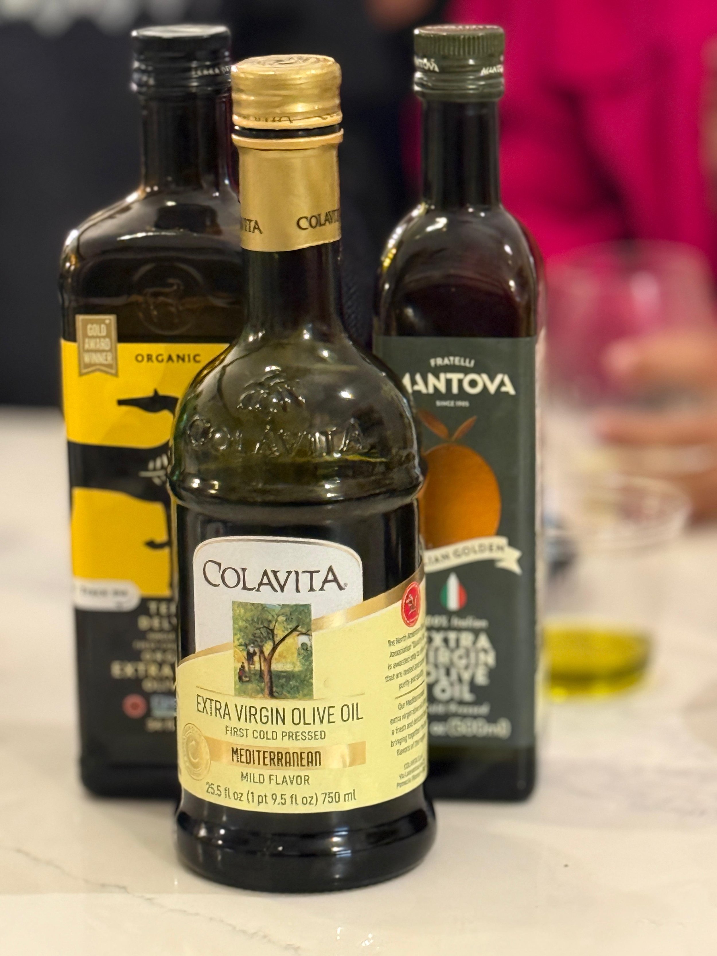 Three different brands of olive oil in glass bottle.