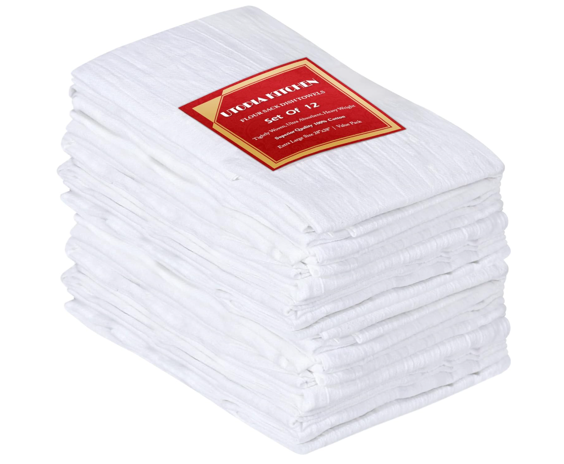A stack of 12 white flour sack dish towels with a red and gold label on top reading "TOPA KITCHEN, FLOUR SACK DISH TOWELS, Set of 12."