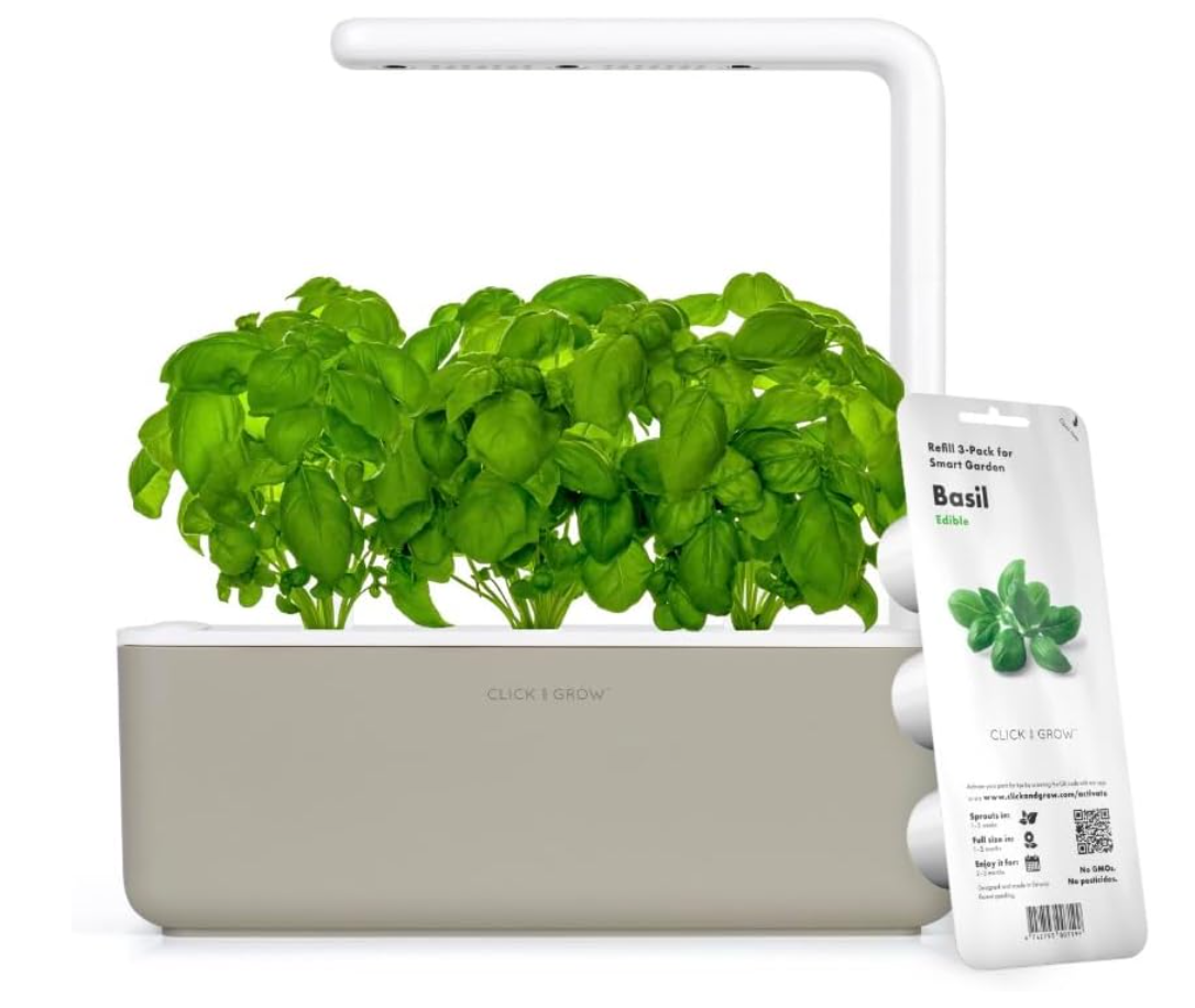 Indoor garden with basil plant in a smart planter and a 3-pack of basil seed refills hanging on the planter.