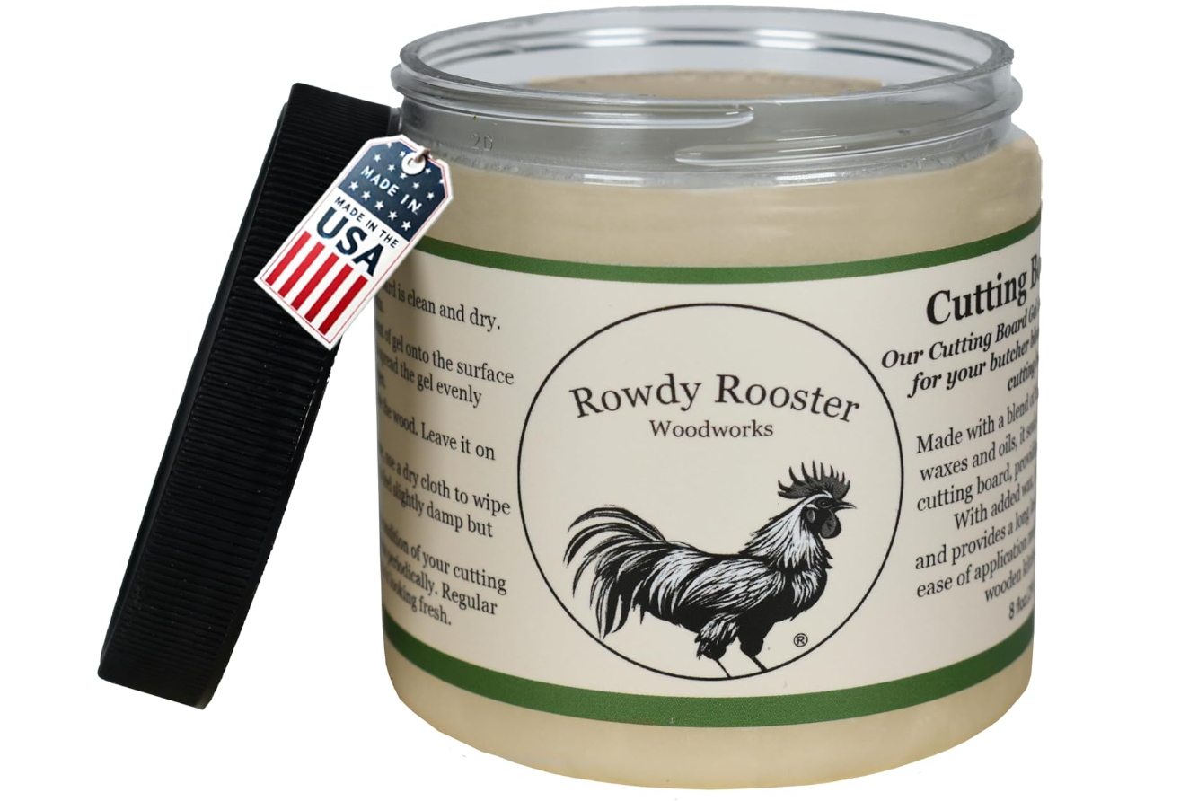 A jar of Rowdy Rooster woodwork cutting board conditioner with a black plastic scraping tool labeled Made in the USA leaning against it.