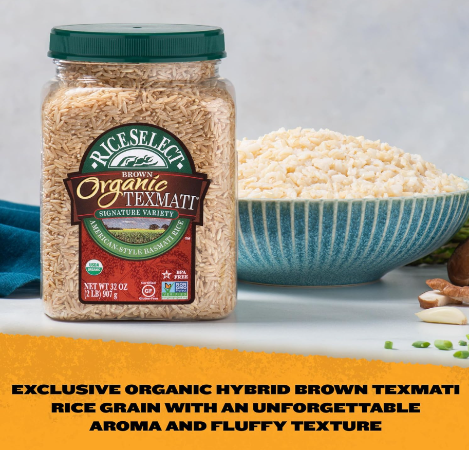 A jar of Rice Select Organic Texmati brown rice next to a textured blue bowl filled with cooked rice, with some chopped green onions and other ingredients on the side.