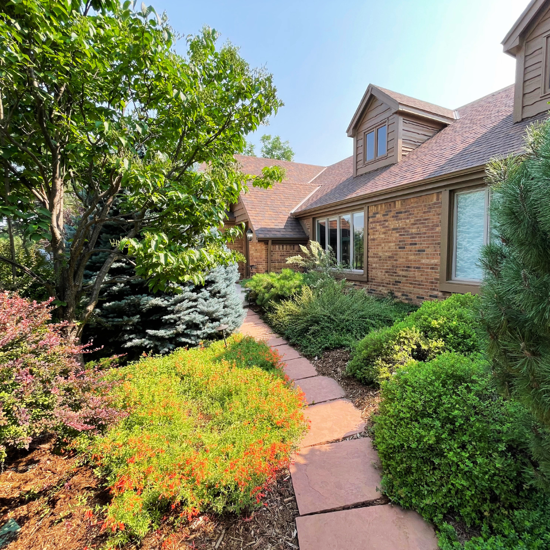 up close image of a home in cherry hillls vilage. There is a flagstone paver path and a beautiful landscape.