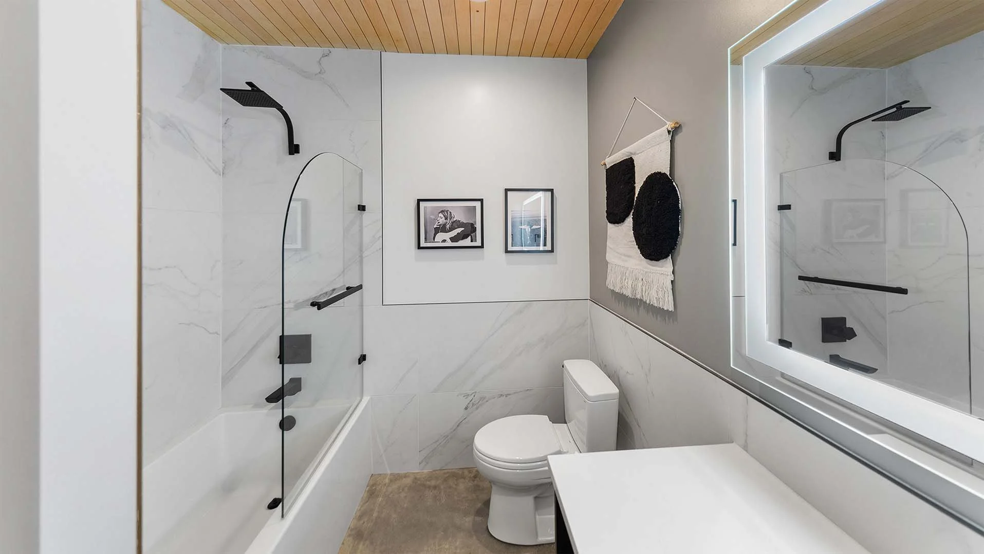 RAVN HAUS vacation rental Wy'East En Suite with marble tile, tub shower combo, and matte black fixtures on Mt. Hood, Oregon.