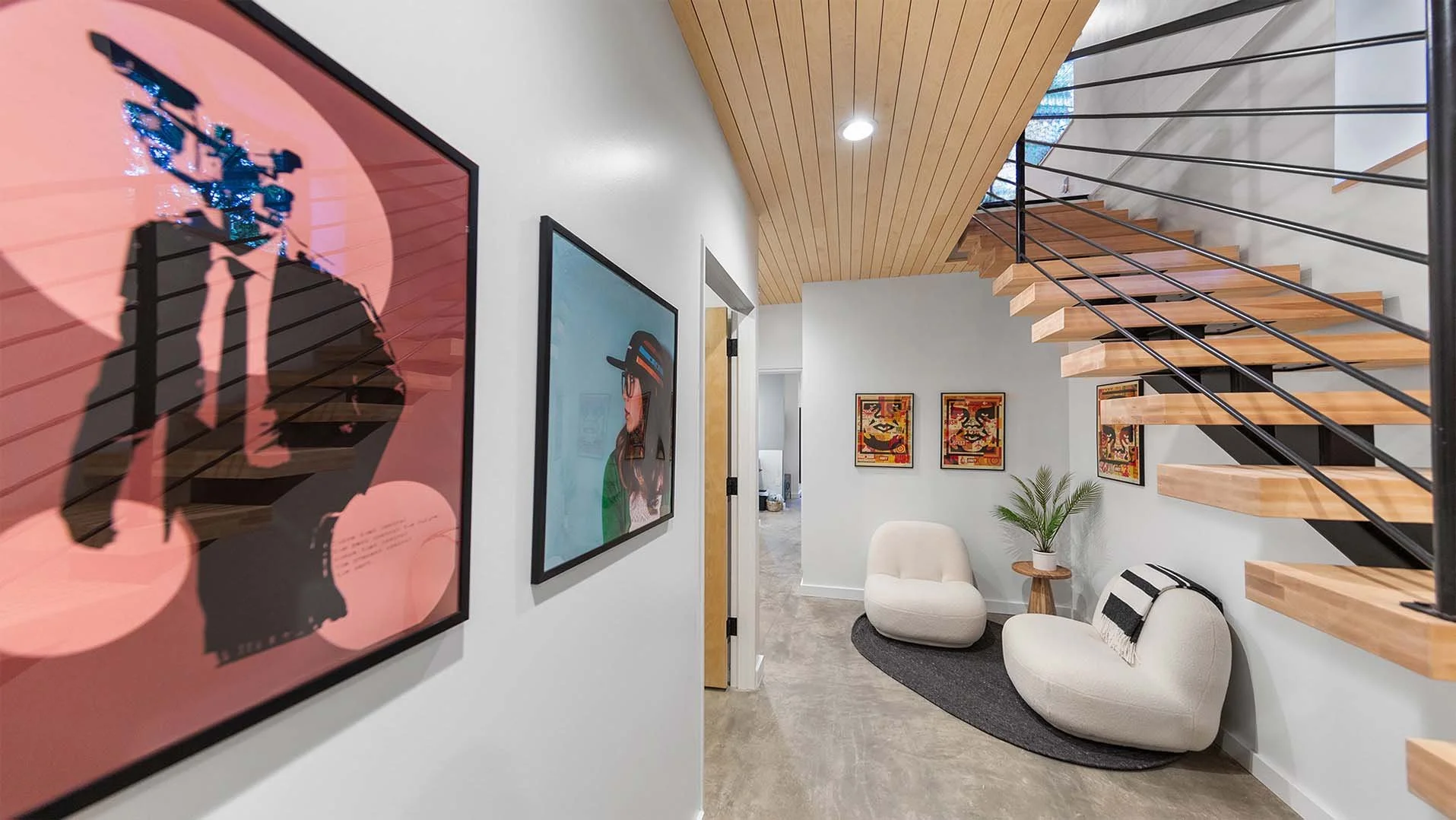 RAVN HAUS vacation rental Forest Floor Nook with boucle lounge chairs, bold art, and floating staircase on Mt. Hood, Oregon.
