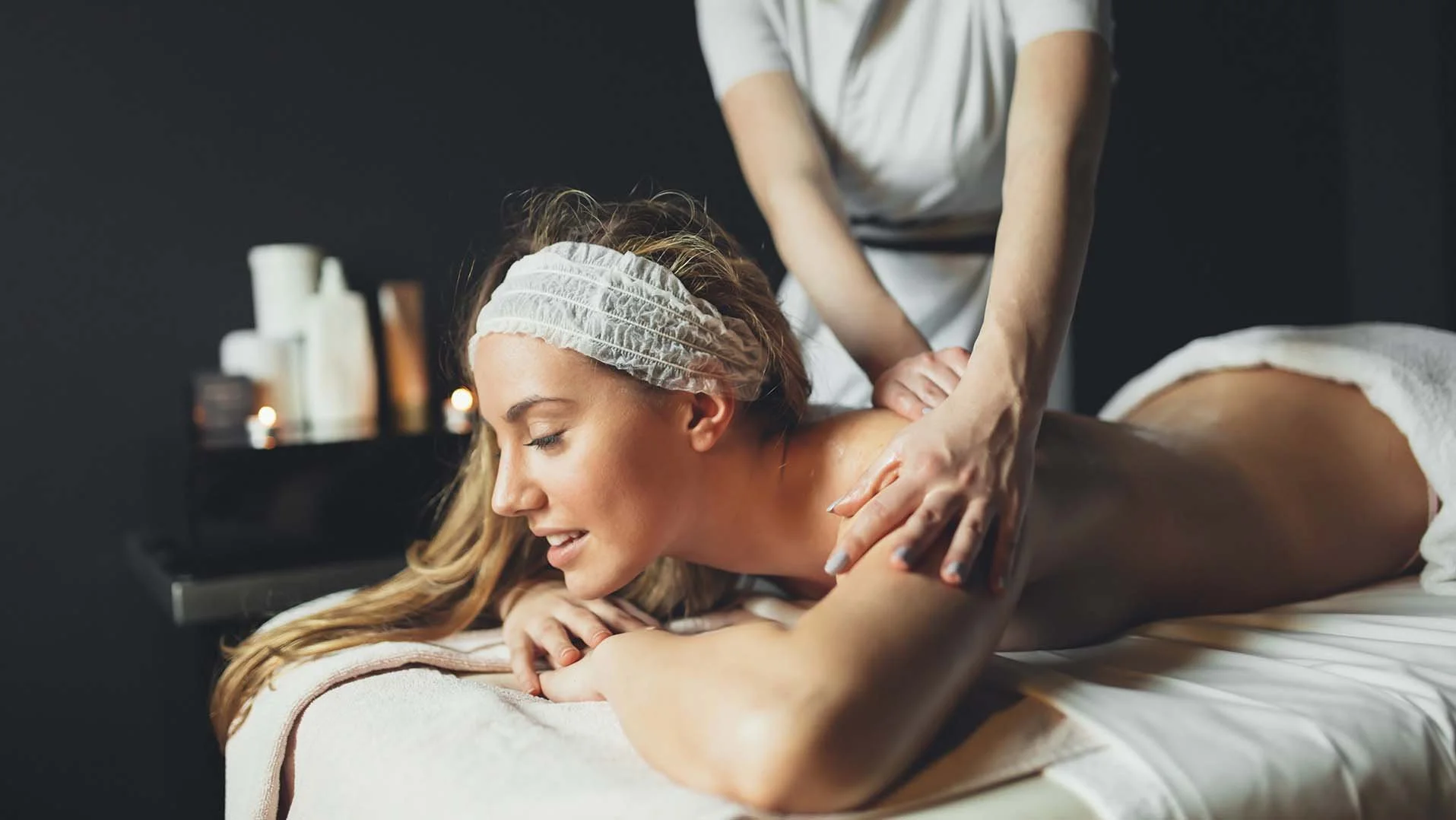 Guest receiving a professional massage inside RAVN HAUS Mt. Hood vacation rental as part of the on-site wellness offerings.