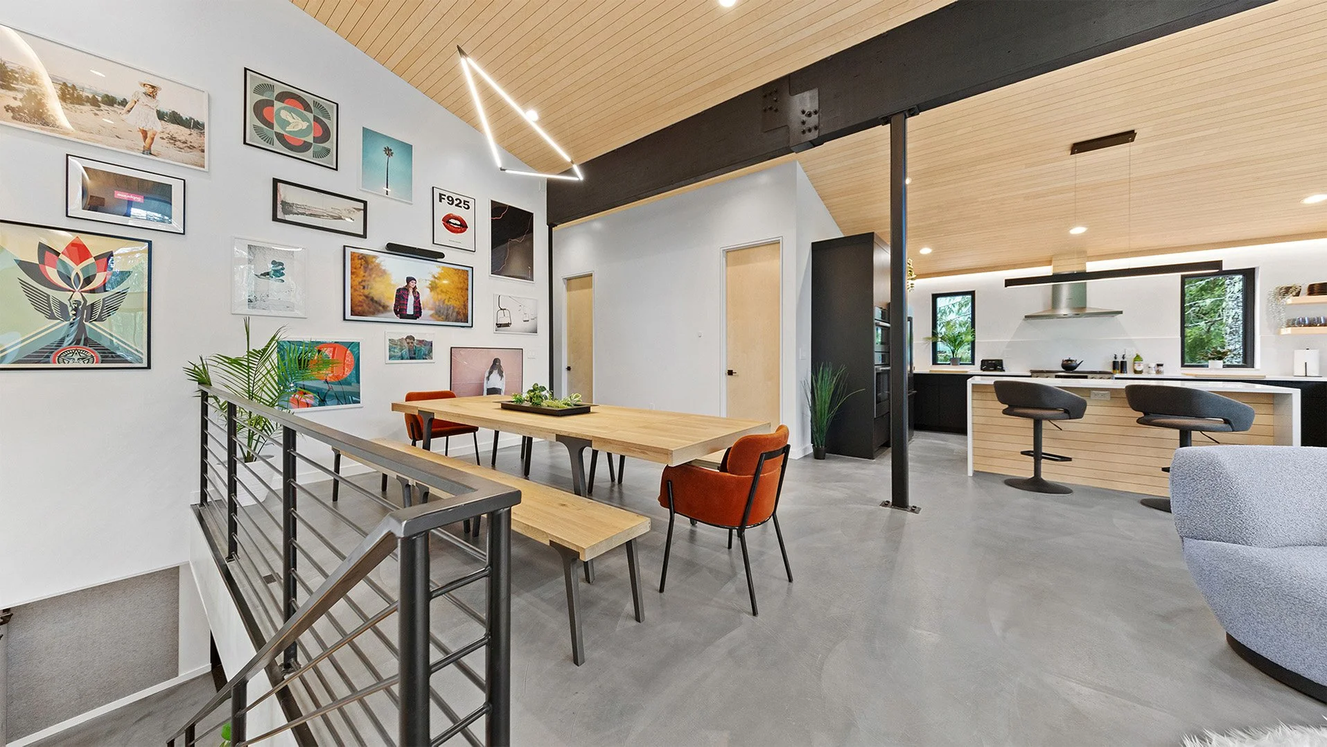 Canopy dining room at RAVN HAUS Mt. Hood vacation rental with gallery wall artwork leading into the modern kitchen.