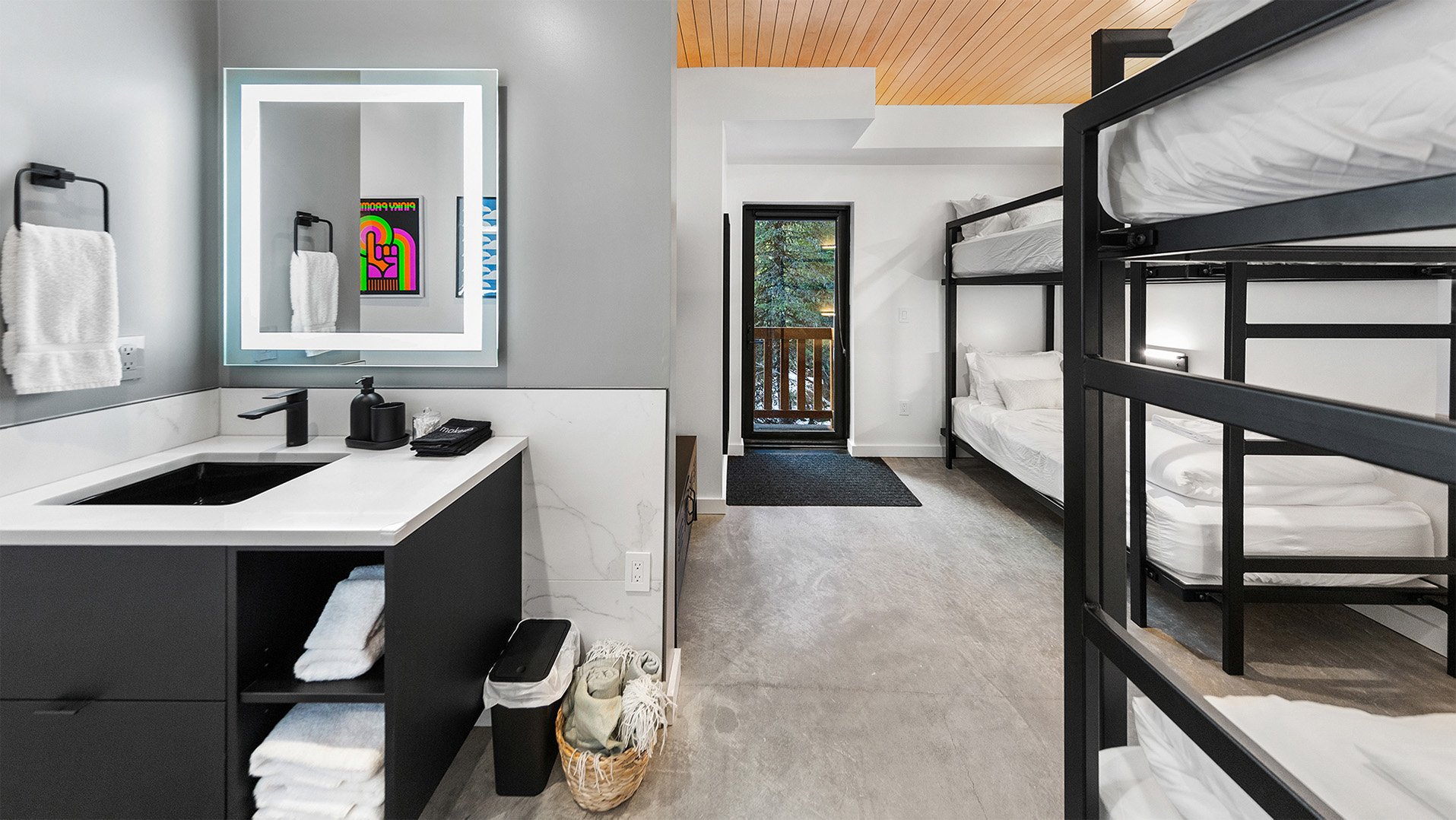 RAVN HAUS vacation rental Elevate Bunk Room with LED vanity, custom black bunks, and forest balcony door on Mt. Hood, Oregon.