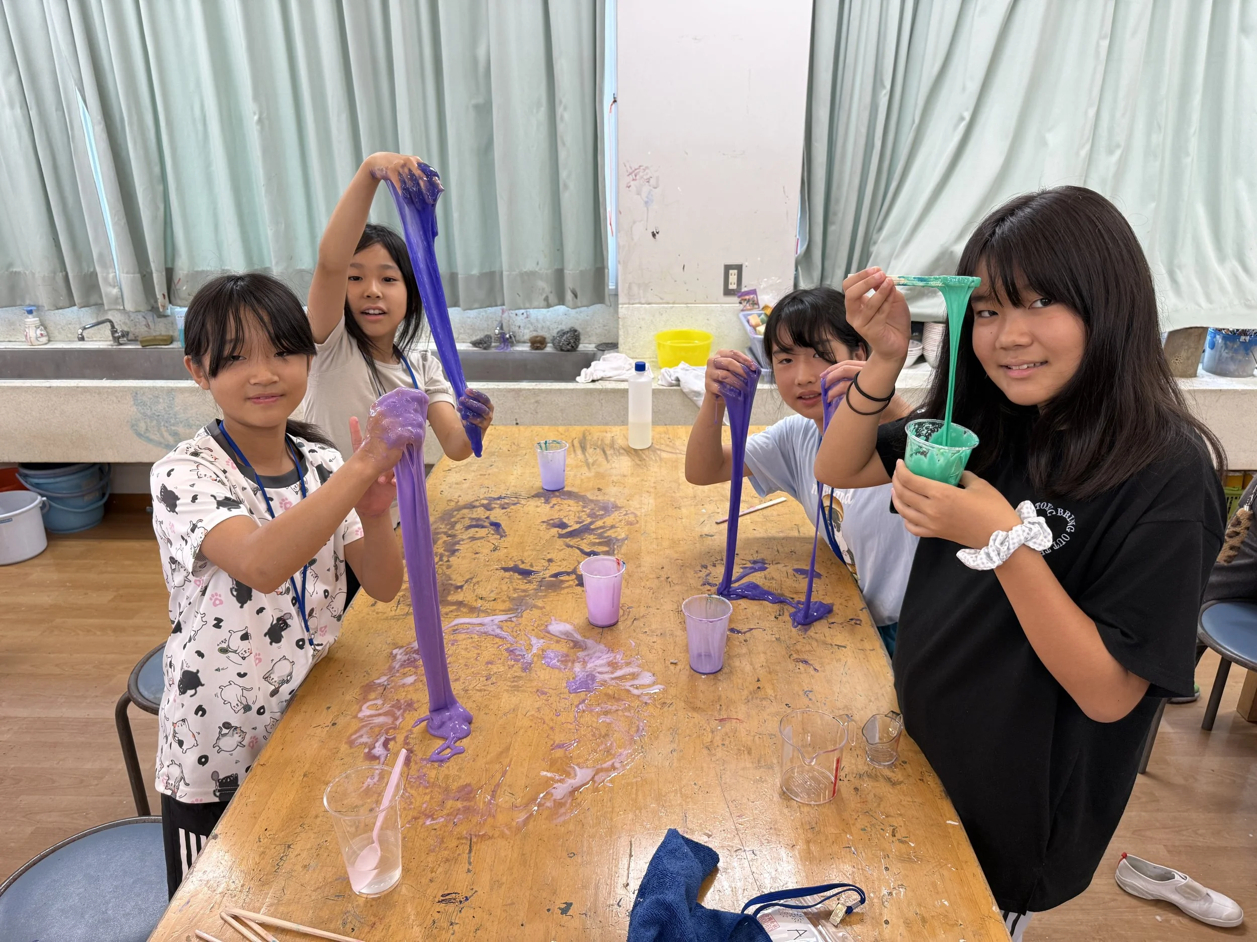 4人の子どもがテーブルでカラフルな粘土遊びをしている様子