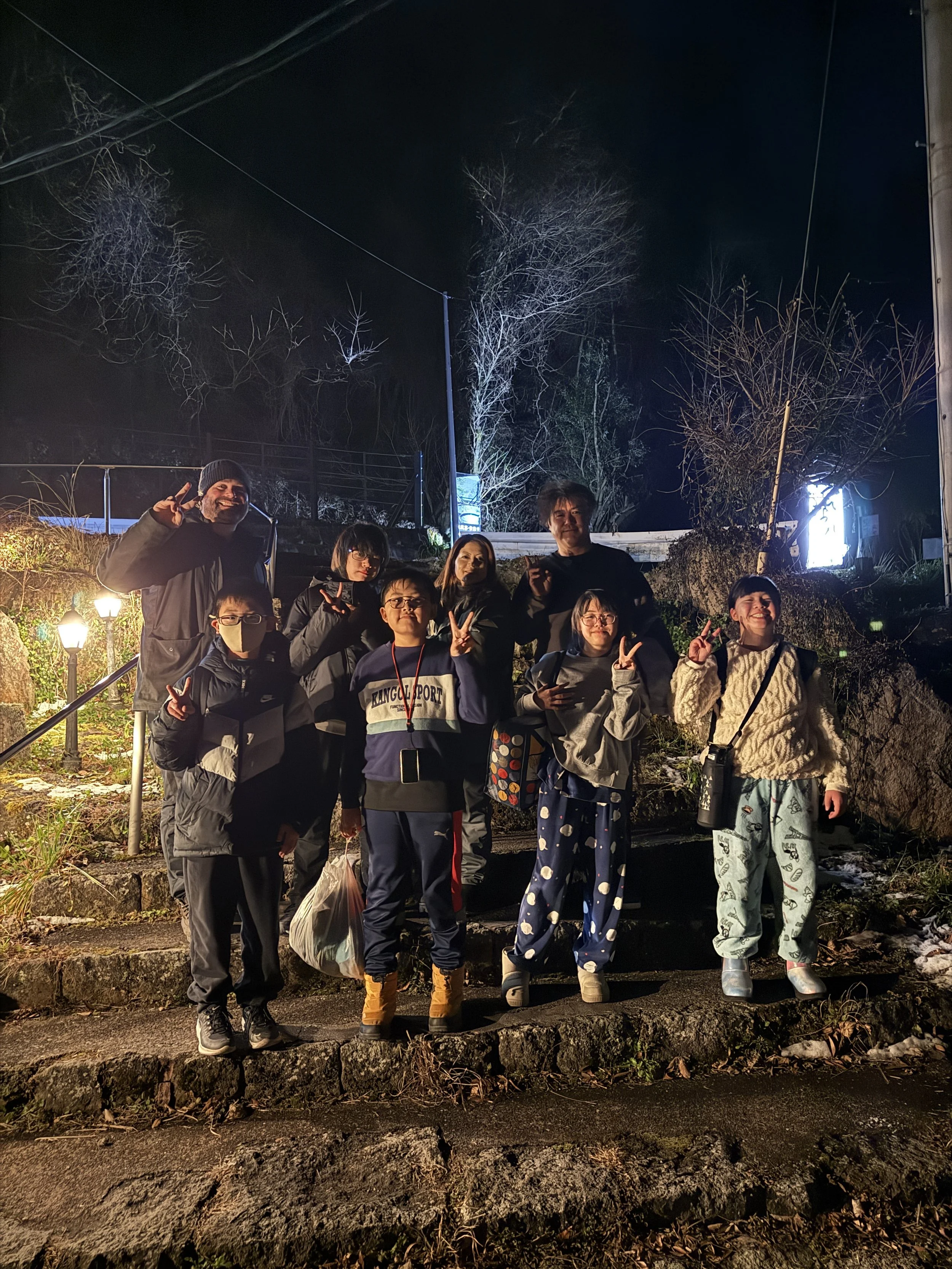 夜に屋外でグループの人々がポーズをとっている写真