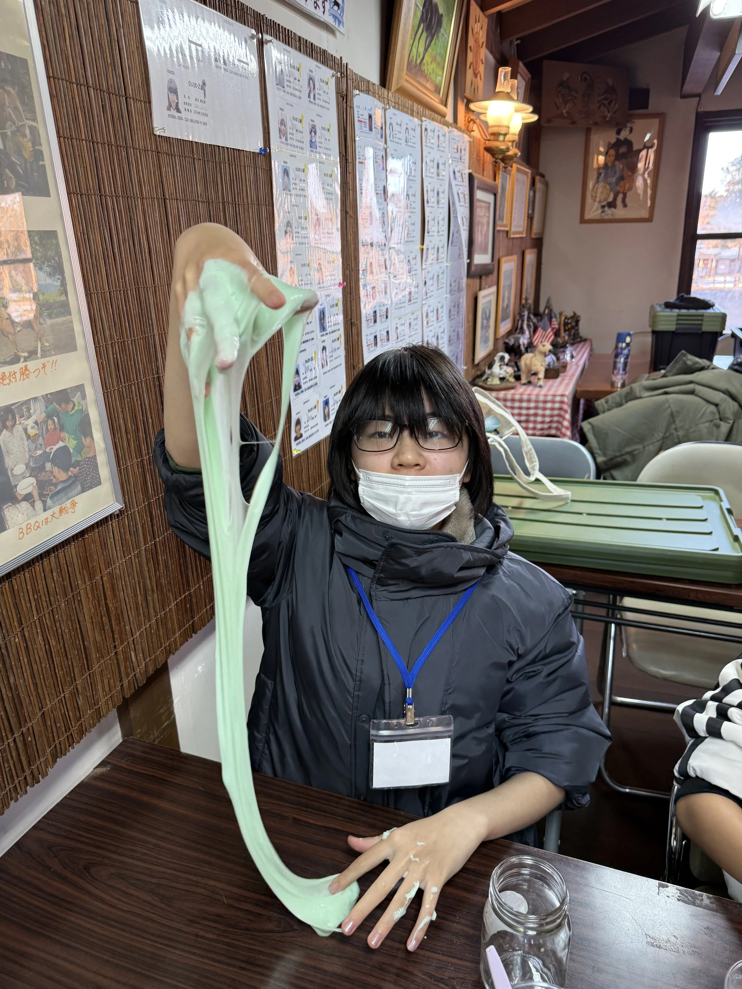 黒いジャケットを着た女性が、手に持って緑色の伸びるスライムを見せている。背景には壁に貼られた紙や絵画、テーブルと椅子が見える。」}》}}}}}}}}}}}}}】】】}】}】}】}】}】}】}】}】}】}】}】}】}】}】}】}】}】}】}】}】}】}】}】}】}】}】}】}】}】}】}】}】}】}】}】}】}】}】}】}】}】}】}】}】}】}】}】}】}】}】}】}】}】}】}】}】}】}】}】}】}】}】}】}】}】}】}】}】}】}】}】}】}】}】}】}】}】}】}】}】}】}】}】}】