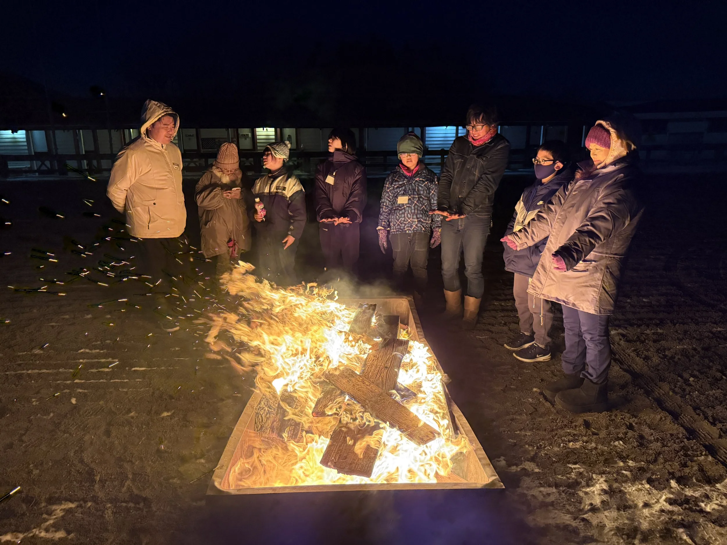 夜、その中で人々が火を囲んでいます。