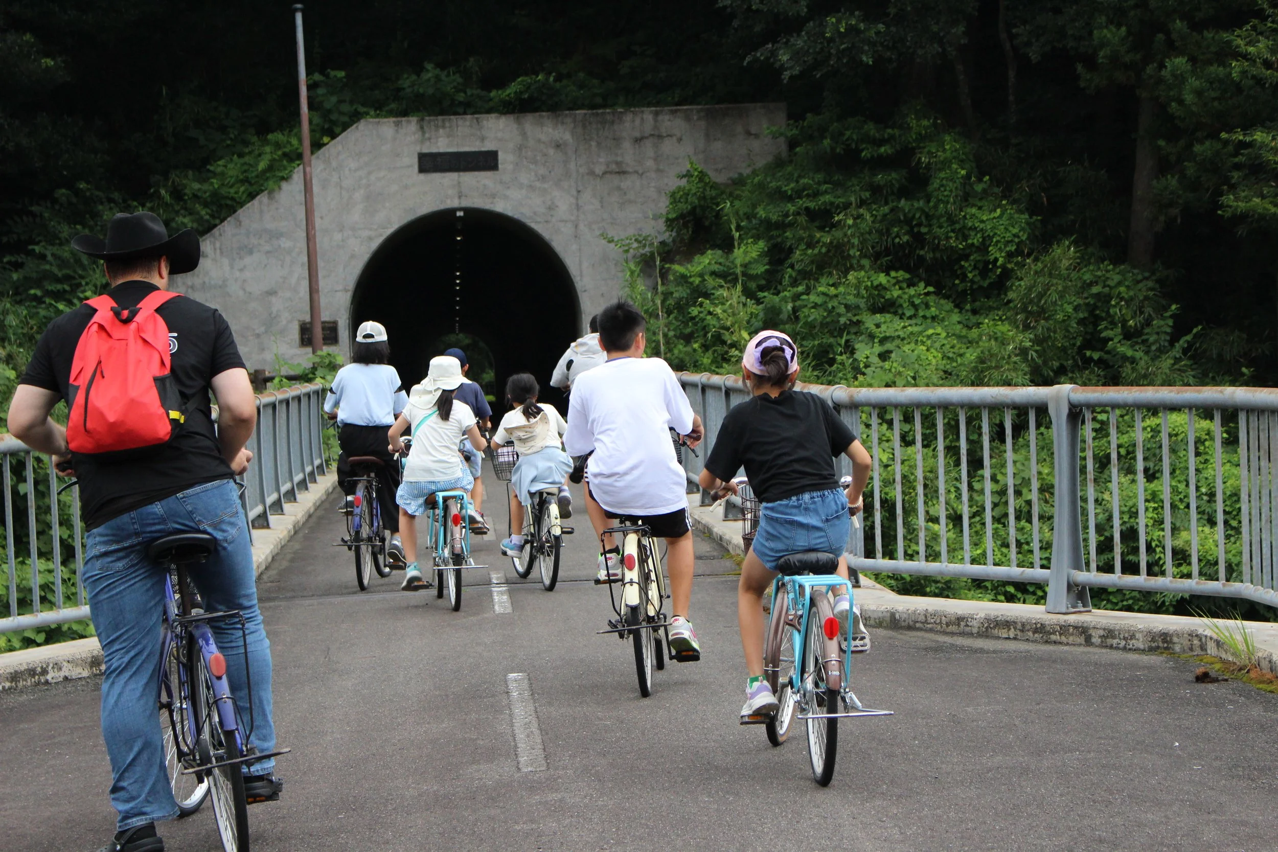 多くの人々が自転車に乗ってトンネルに向かって走っている風景
