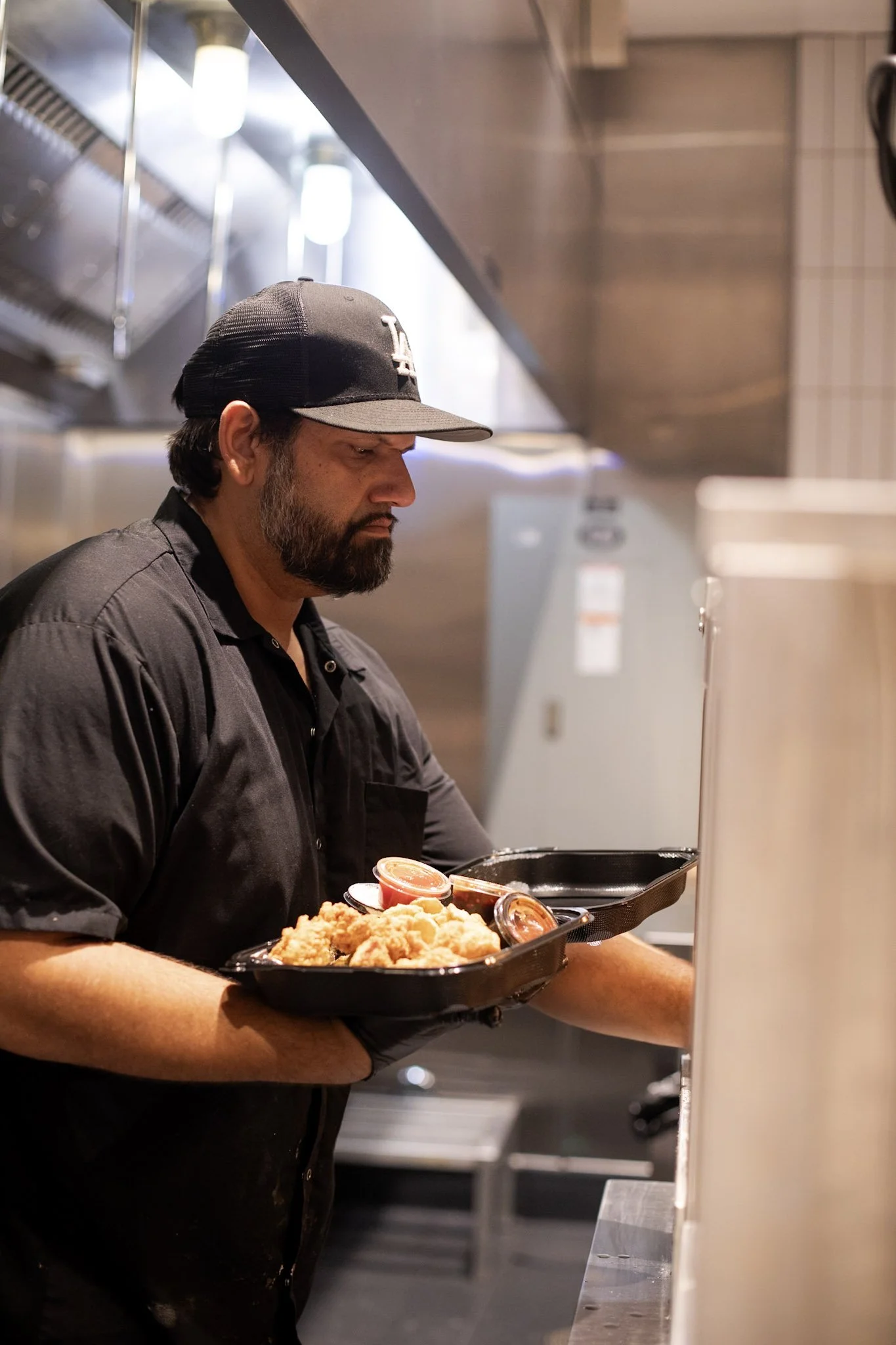 Photo of Mike Gill, creator of Nugtown, holding a tray of food and sauce.