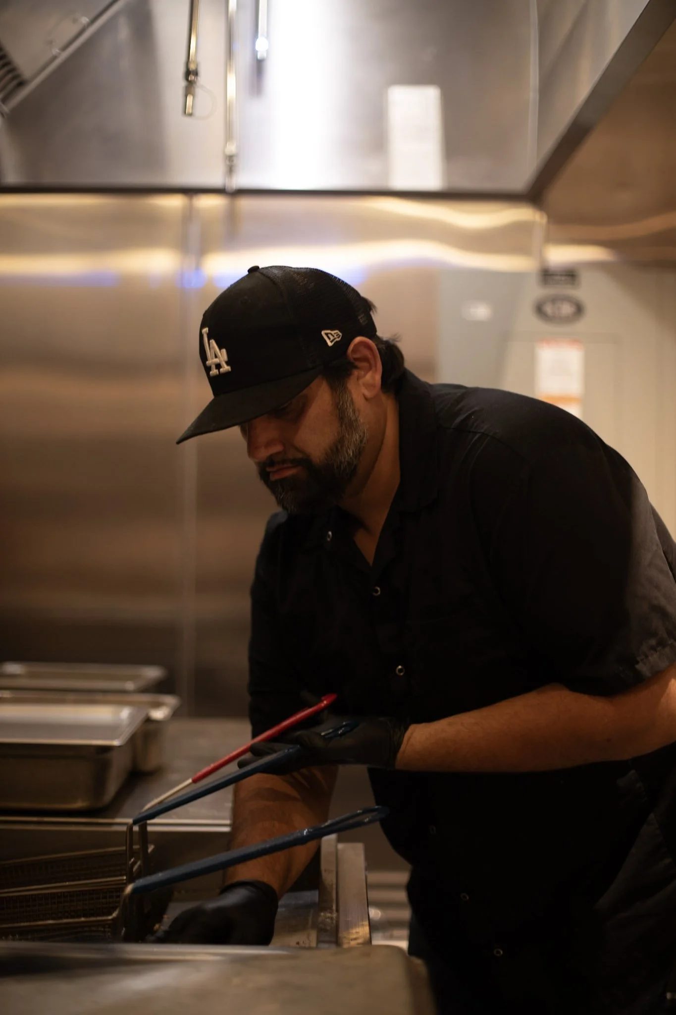 Photo of founder of Nugtown, grabbing fryer baskets from the deep frier.