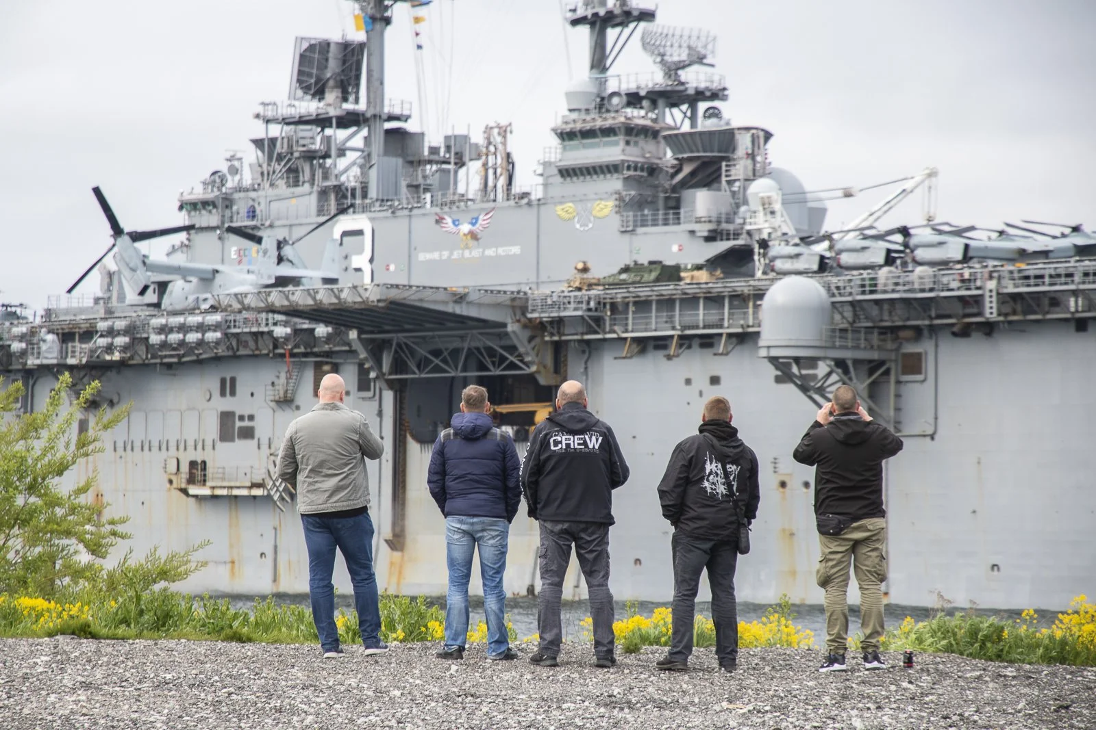 Five men observing the USS Kearsarge, American landing ship, in Tallinn, Estonia.
