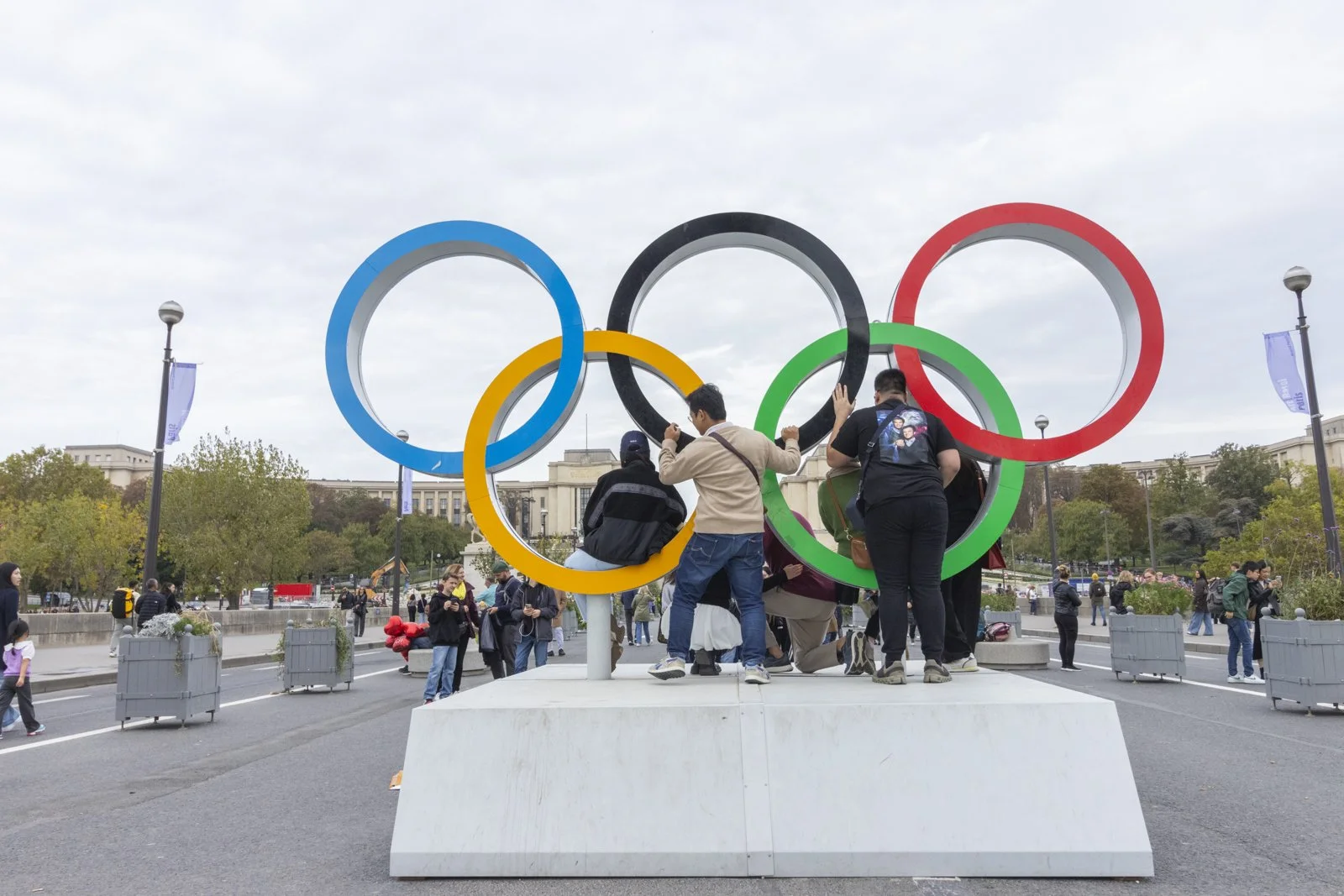 People gather around the Olympic rings sculpture in Paris, France.