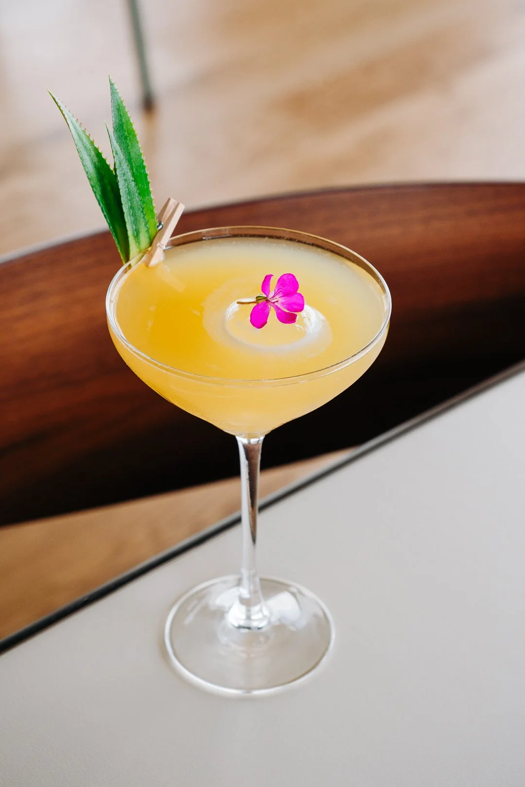 Photographie épurée d'un cocktail à base de vin Chambre d'Amour Lionel Osmin avec garniture florale