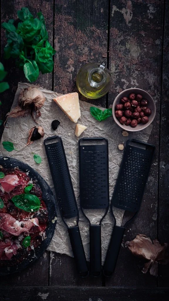 Composition flat lay en studio présentant la gamme de râpes Microplane Black Sheep et ingrédients italiens