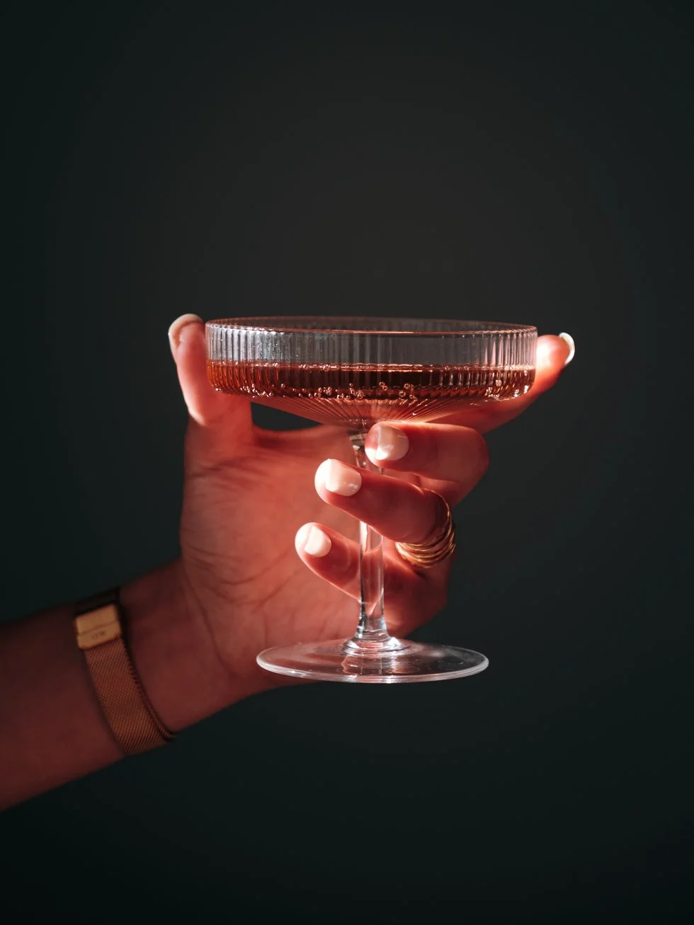 Plan rapproché sur une mannequin main tenant une coupe de pétillant rosé Pinky Bubbles shooté à Monein