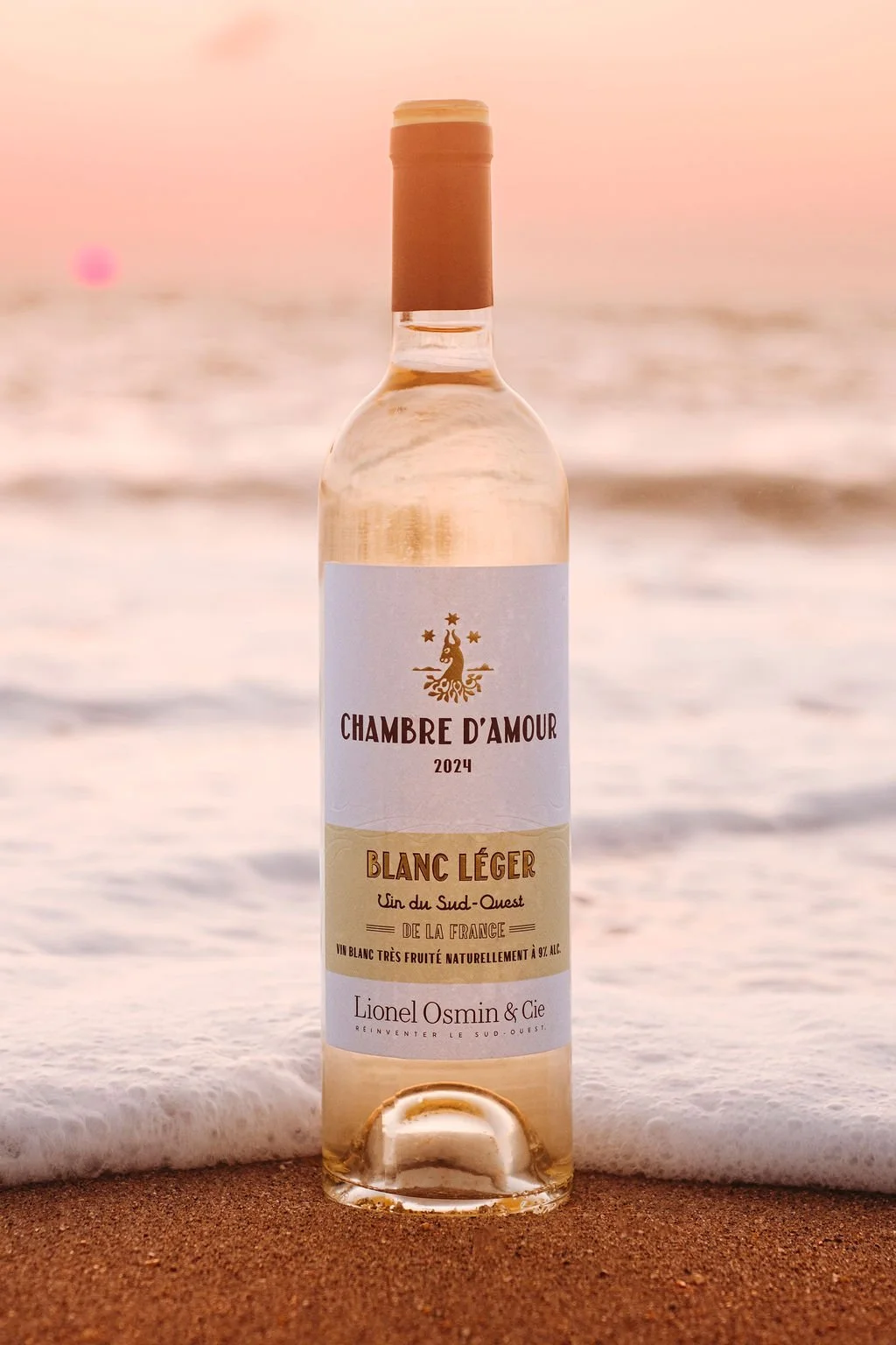 Bouteille de rosé sur le sable d'Anglet sous une lumière dorée de fin de journée