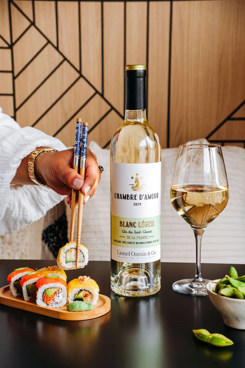 Main tenant des sushis pour un accord mets et vins avec le blanc sec Lionel Osmin lors d'un shooting au Pays Basque