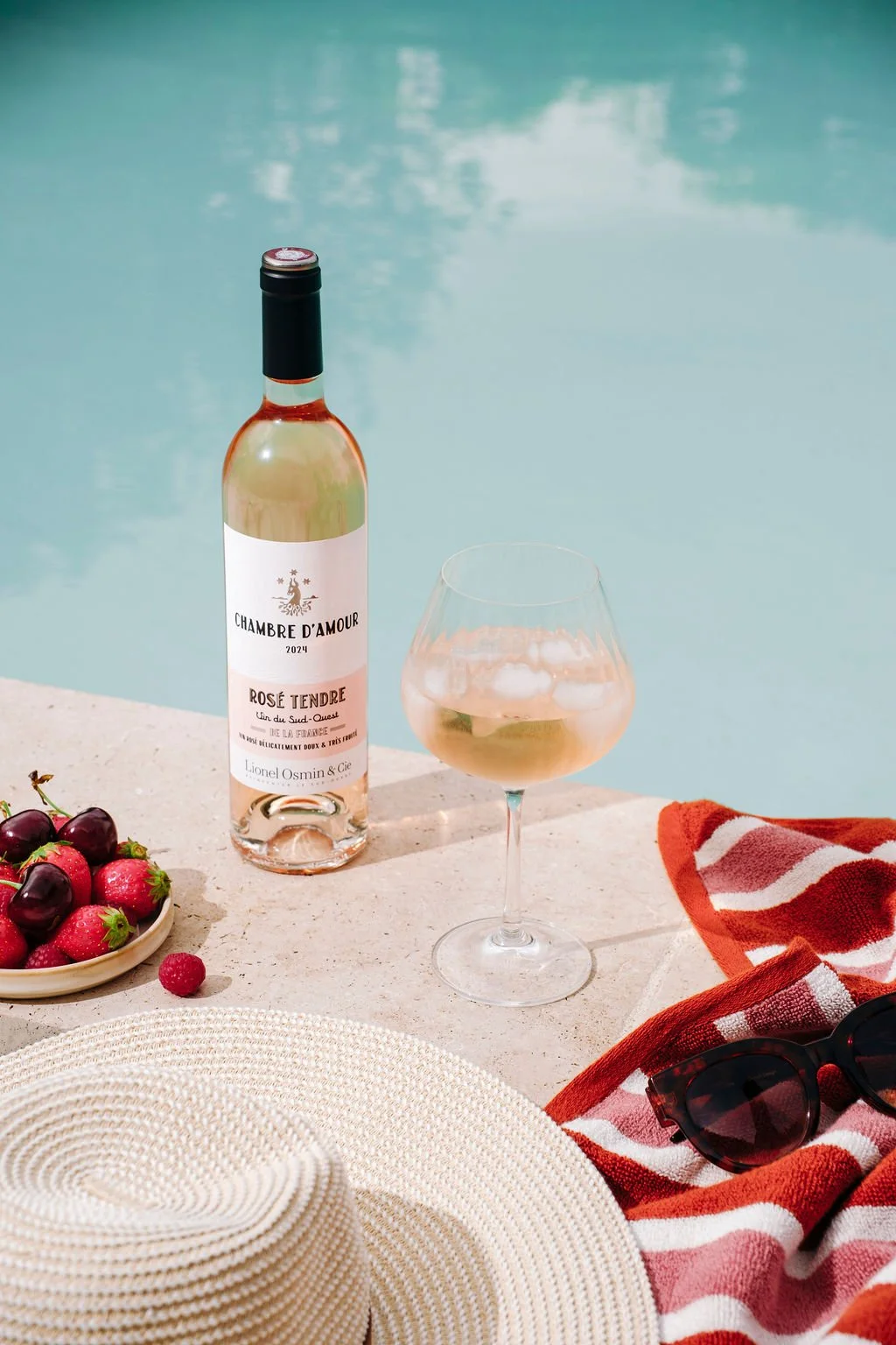 La cuvée rosé tendre Chambre d'Amour mise en scène au bord d'une piscine pour un shooting aux vibes estivales