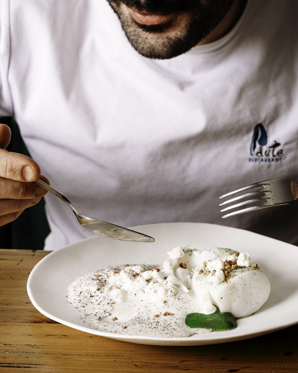 Détail d'un plat blanc épuré avec touche de vert