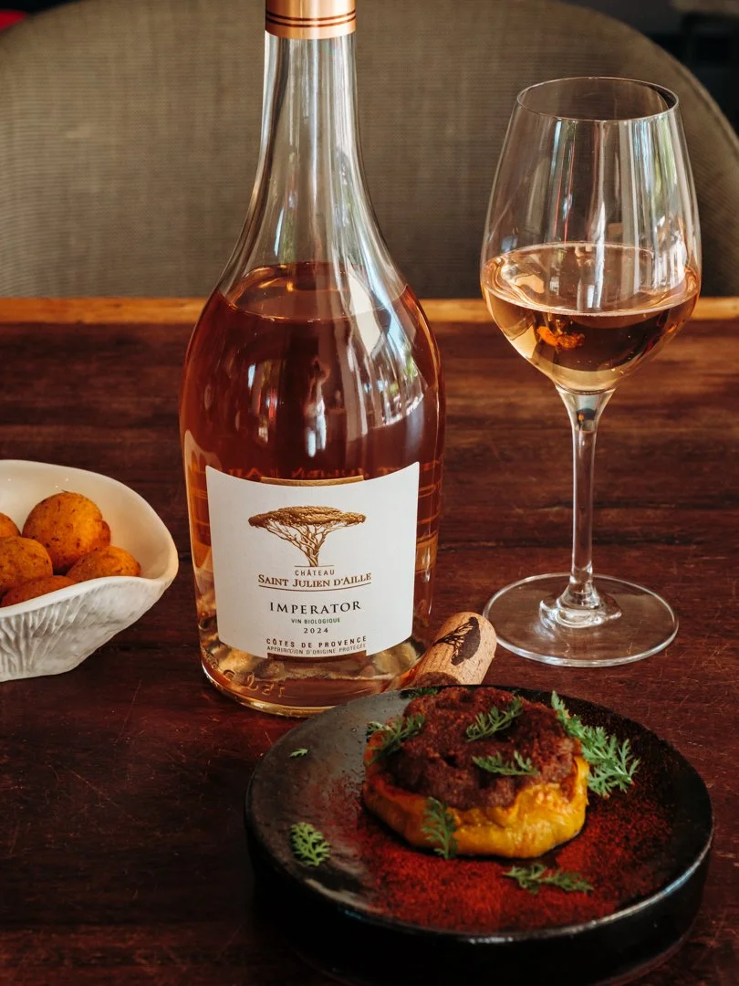 Bouteille de vin rosé Imperator avec verre et plat cuisiné coloré pour du contenu Instagram