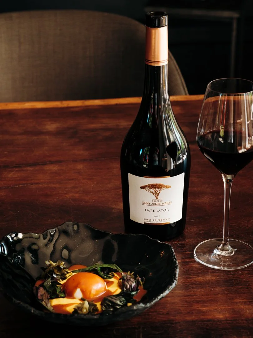 Bouteille de vin rouge Imperator avec verre et plat de viande lors du shooting à l'Auberge Basque