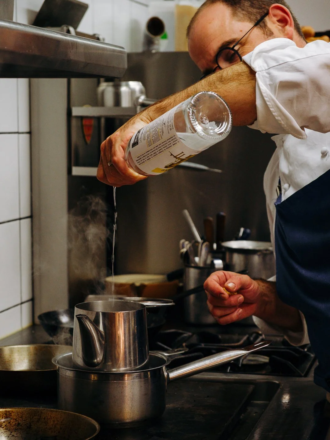 Chef versant l'armagnac Dartigalongue dans une casserole fumante