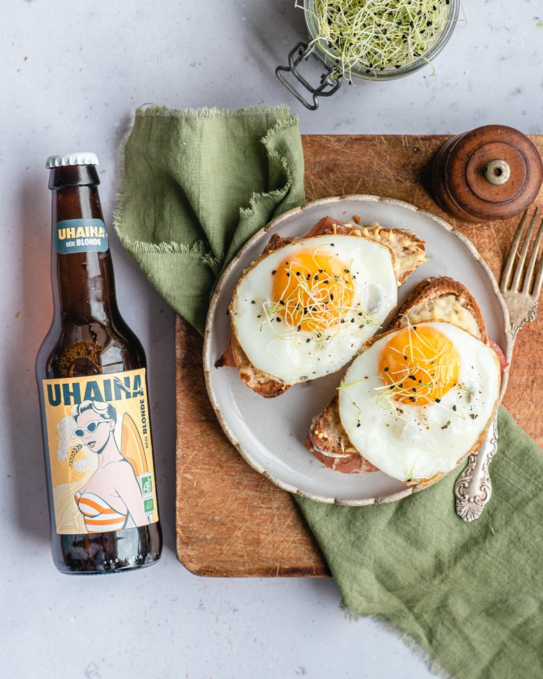 Assiette d'œufs au plat sur tartines au jambon avec bouteille Uhaina Blonde, recette bière