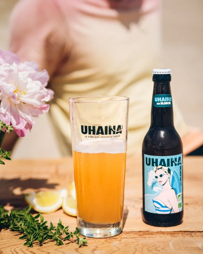 Verre de bière blanche Uhaina servi avec citron et thym, stylisme culinaire extérieur