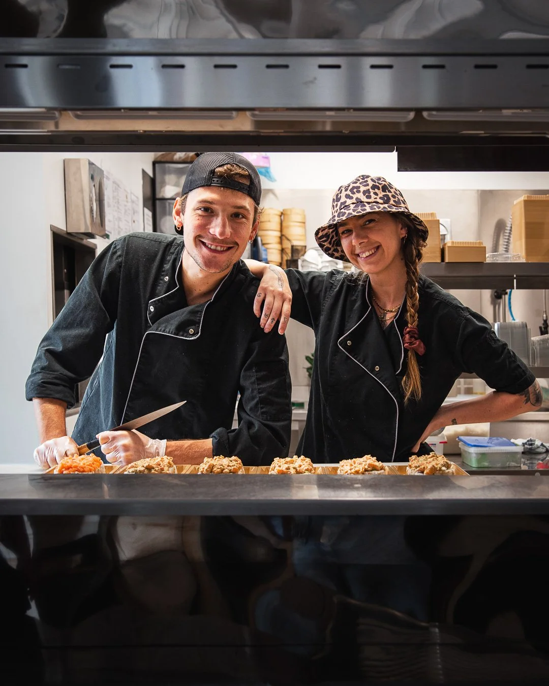 Deux chefs de cuisine souriants derrière le passe-plat lors d'un reportage photo restaurant à hossegor