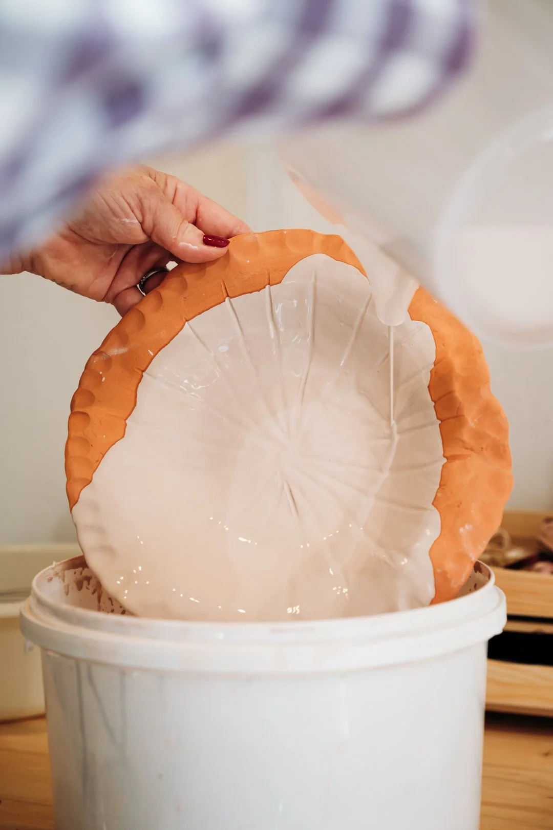 Emaillage d'une assiette en terre par une potière de Pau