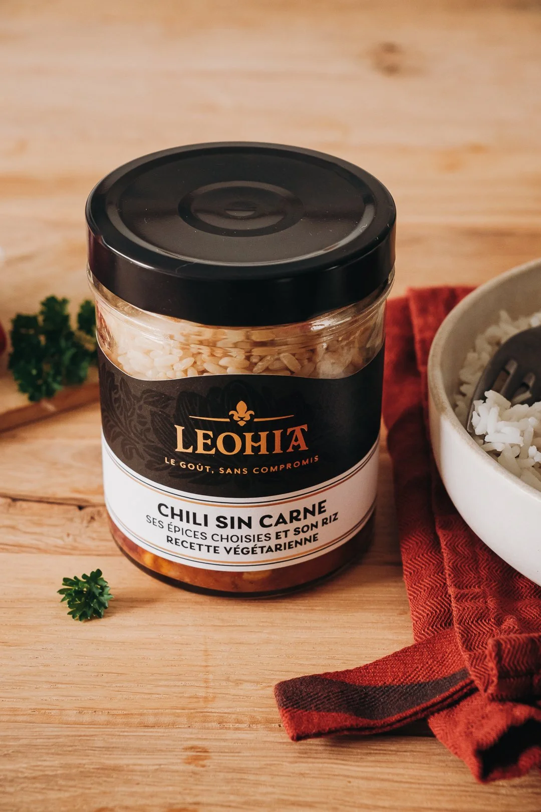 Bocal de Chili Sin Carne végétarien Leohia sur une table en bois avec riz et persil, création de contenu culinaire