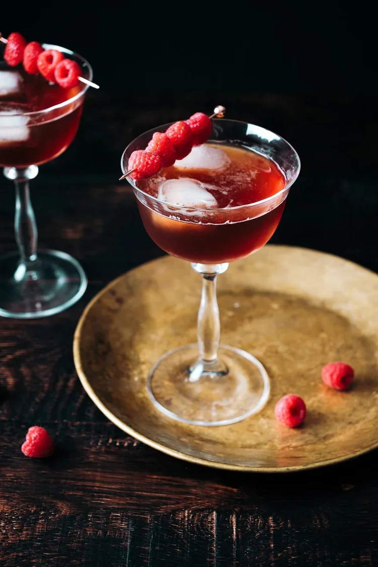 Deux cocktails à base d'eau-de-vie Brana sur plateau doré, photographie studio ambiance moody